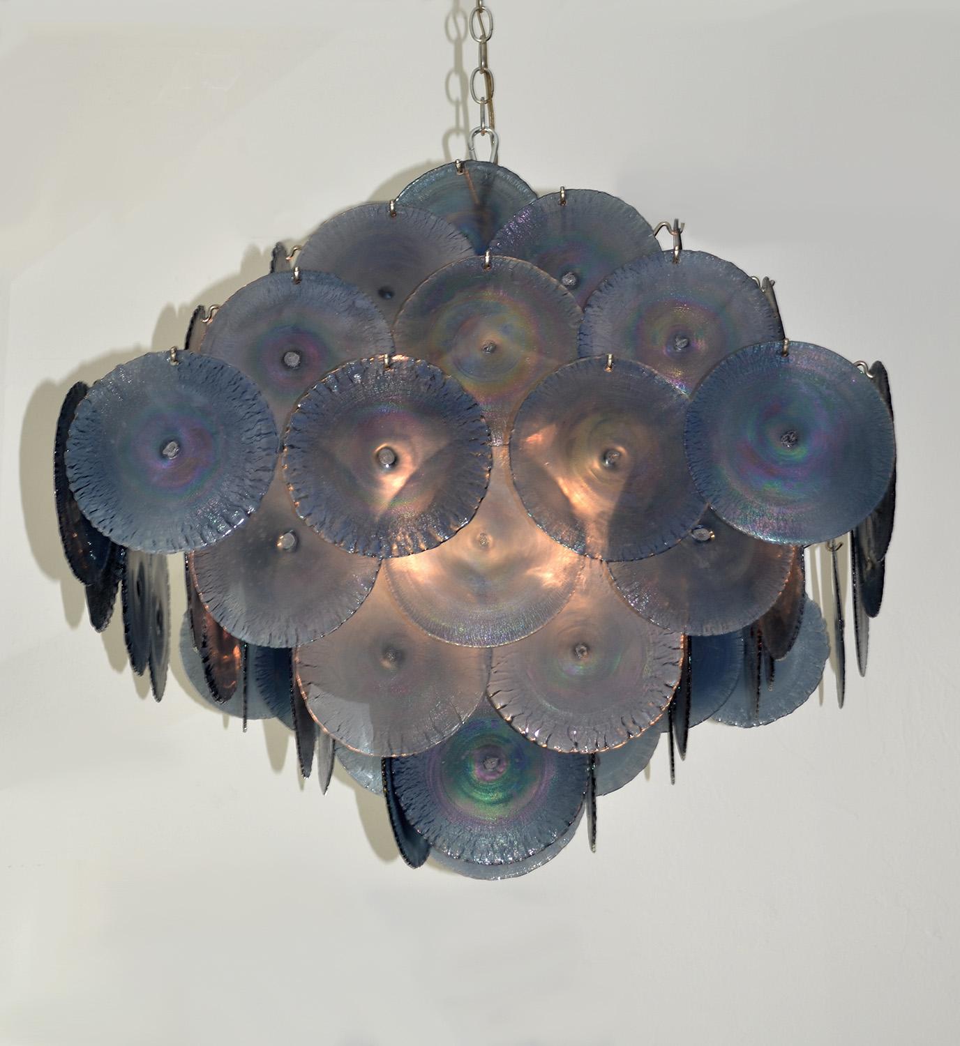Large iridescent purple Murano glass chandelier by Vistosi, Italy, 1970s. Double pyramid-shaped composed of iridescent hand blown Murano glass discs that shimmer and glow like soap bubbles. Twelve bulbs on a central tiered frame. Chain not included.