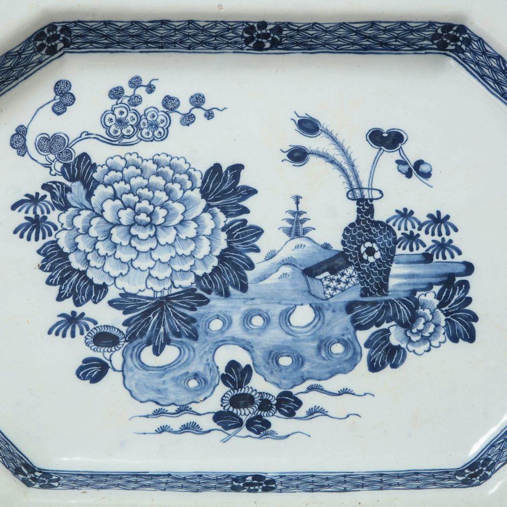 Of octagonal form; decorated with a vase, chrysanthemums and other flower blossoms in a stylized garden setting.
