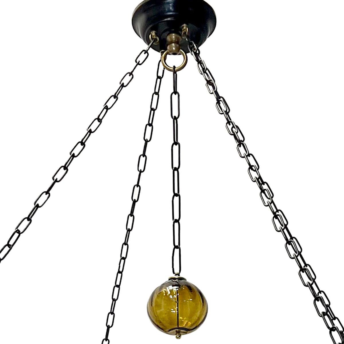 Un lustre suédois en fer forgé de dix-huit lumières, datant des années 1950, avec des pendentifs en verre ambré soufflé.

Mesures :
Diamètre : 48