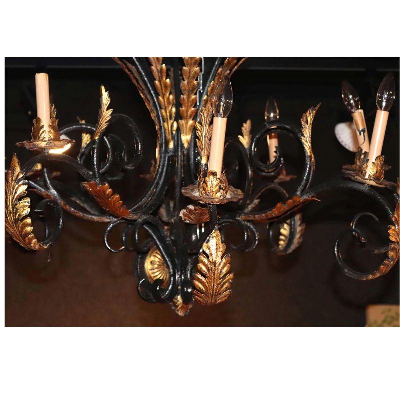 Ein großer Kronleuchter im spanischen Stil mit geschwungenen, vergoldeten Blättern und floralen Details, Eisenbeschlägen und acht Lichtern.