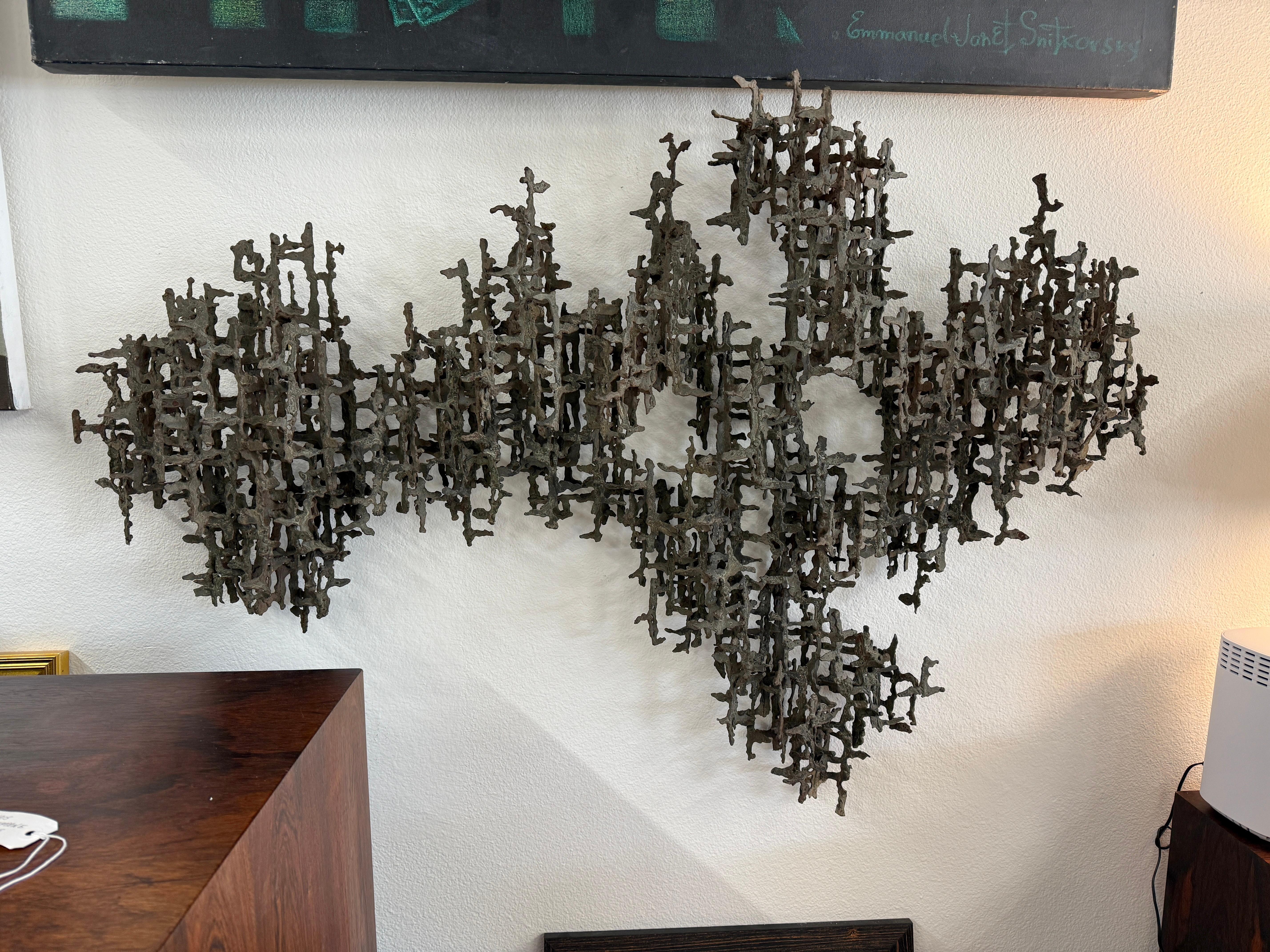 A large welded iron brutalist sculpture. They are sometimes attributed to Marcel Fantoni but we feel comfortable with the Daniel Gluck attribution. The color is a dusty gray. It hand on the wall via two wire loops which we’ve attached. Not Signed