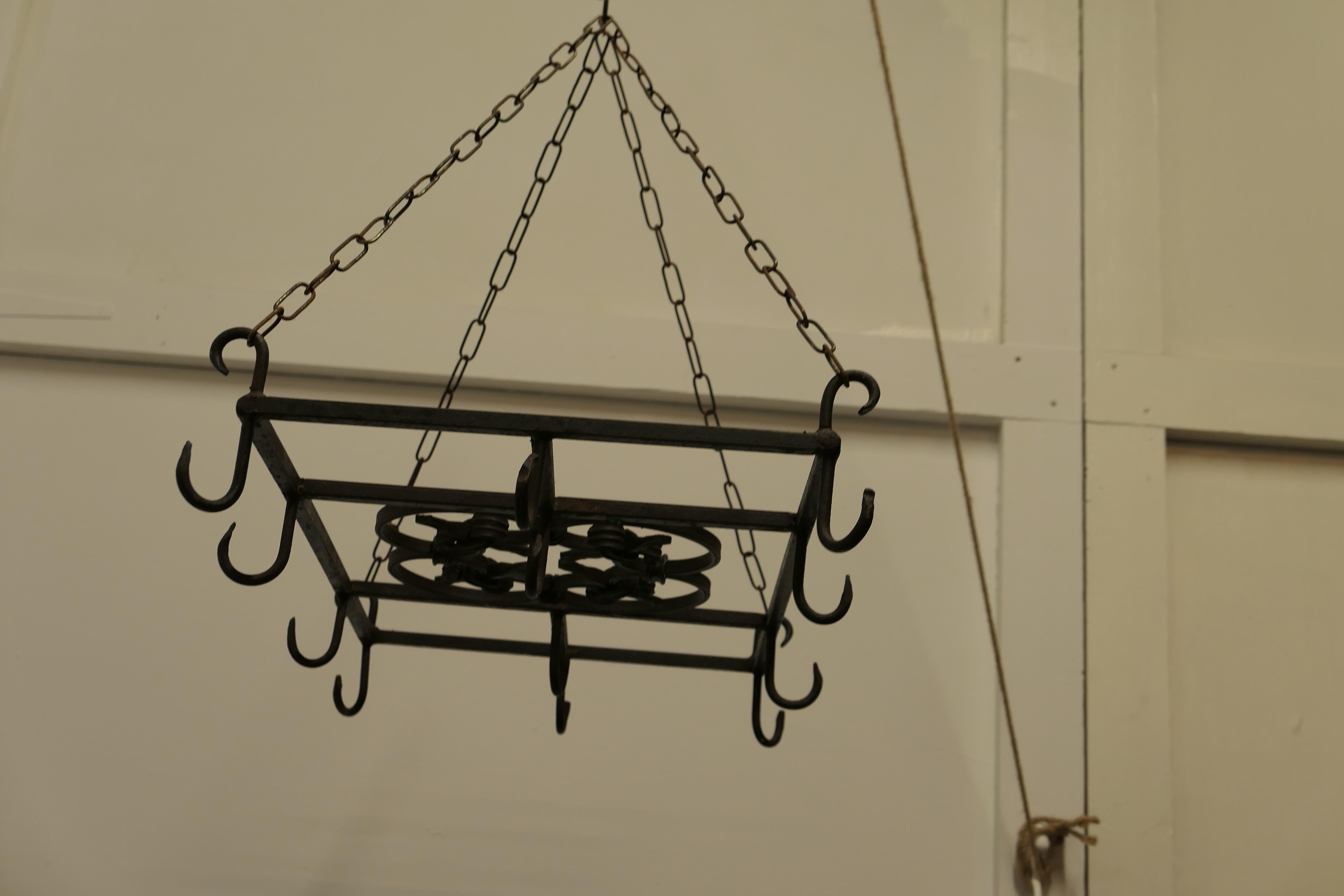 Large iron game hanger, kitchen utensil or pot hanger.

A great piece with lots of character, it hangs on 4 hooked chains, and it has a decorative wrought iron panel at the centre with 12 iron hooks, if you don’t need it to hang your game on how