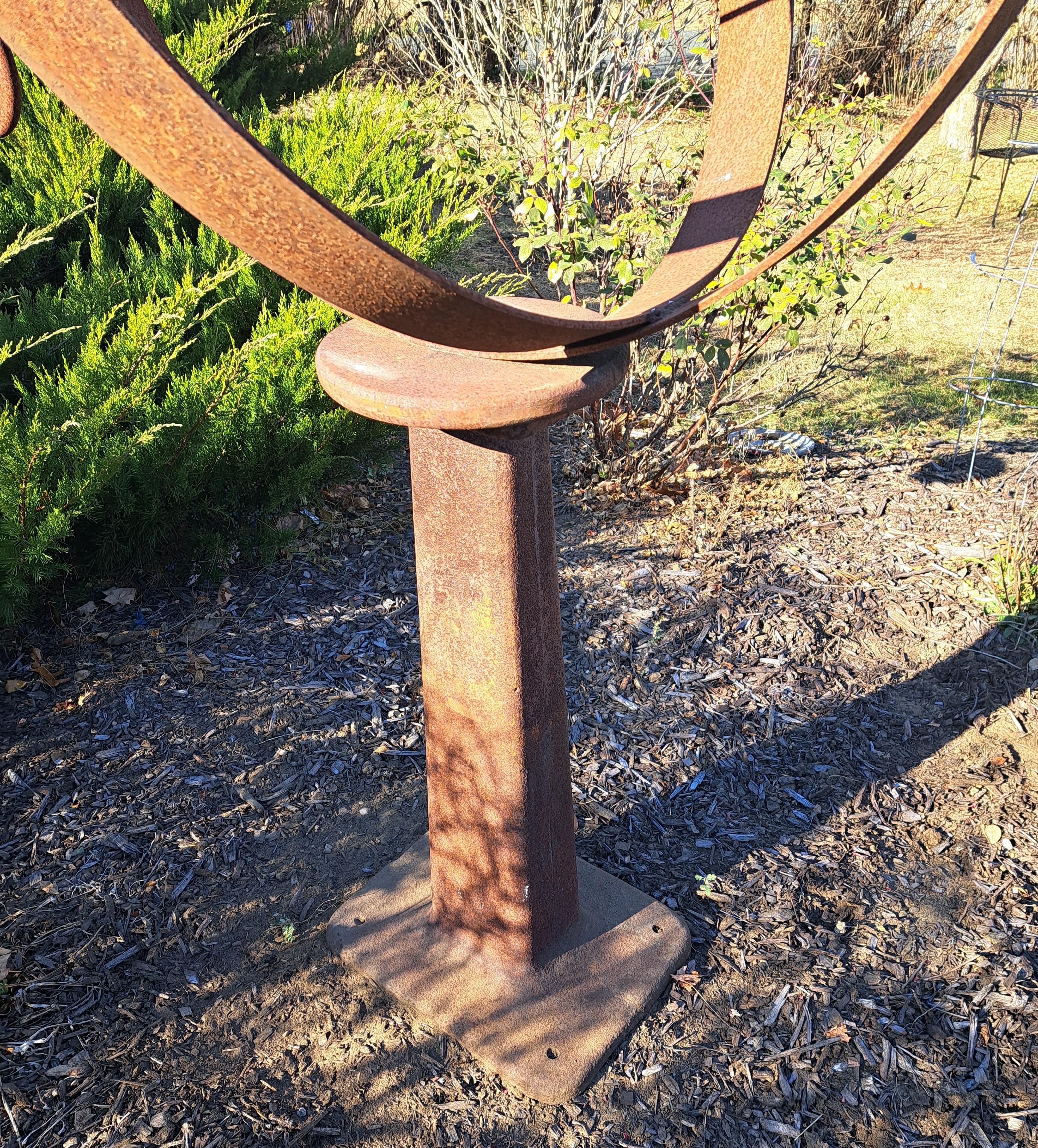 Armillare da giardino in ferro di grandi dimensioni.  Sfera in ferro pesante realizzata artigianalmente e assemblata su una base a macchina.  Finitura arrugginita.  Pesa oltre 200 libbre e può essere imbullonato per fissarlo.  Con una larghezza di