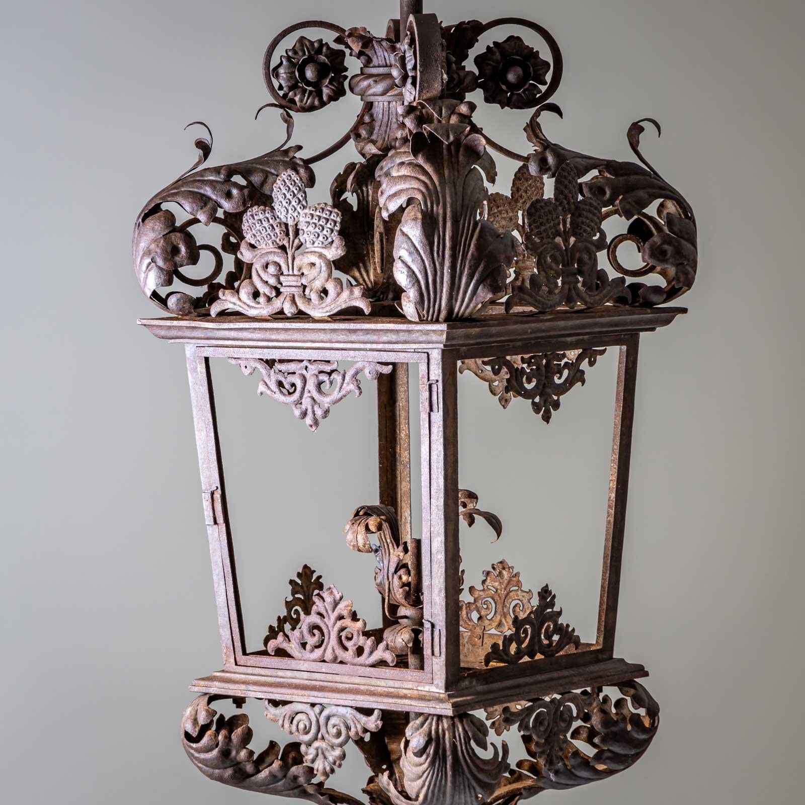Farol monumental de hierro con decoración de hojas y cuerpo esmaltado de seis lados.