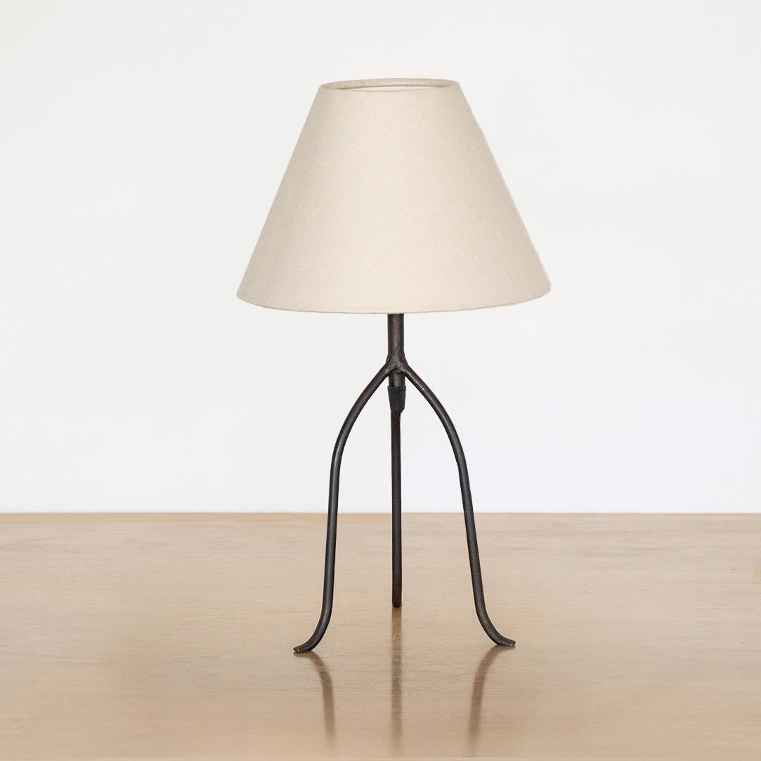 Large iron tripod lamp with slender legs and tapered feet. New wiring and new linen shade. Measures 16.75
