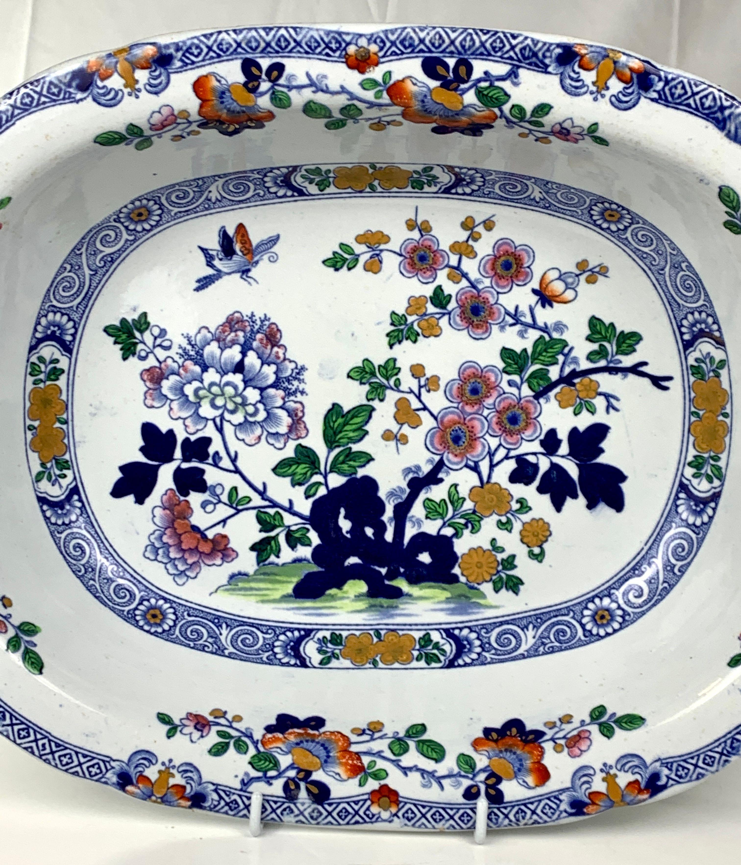 This lovely bowl is decorated with a beautiful garden scene showing a blossoming fruit tree rising from blue rockwork, oversized white and pink peonies, oche-colored chrysanthemums, and a butterfly hovering above.
This beautiful central scene is