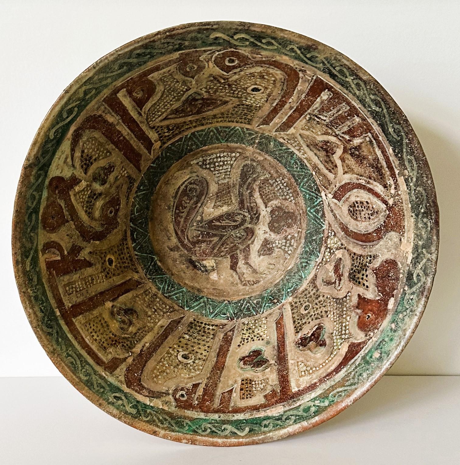 A large earthenware bowl with a deep and wide body supported on a foot ring decorated with incision and slip paint circa 11-12th from Iran when it was under the rule of Seljuk Empire. This bowl features a thinly pottered wall which is covered in