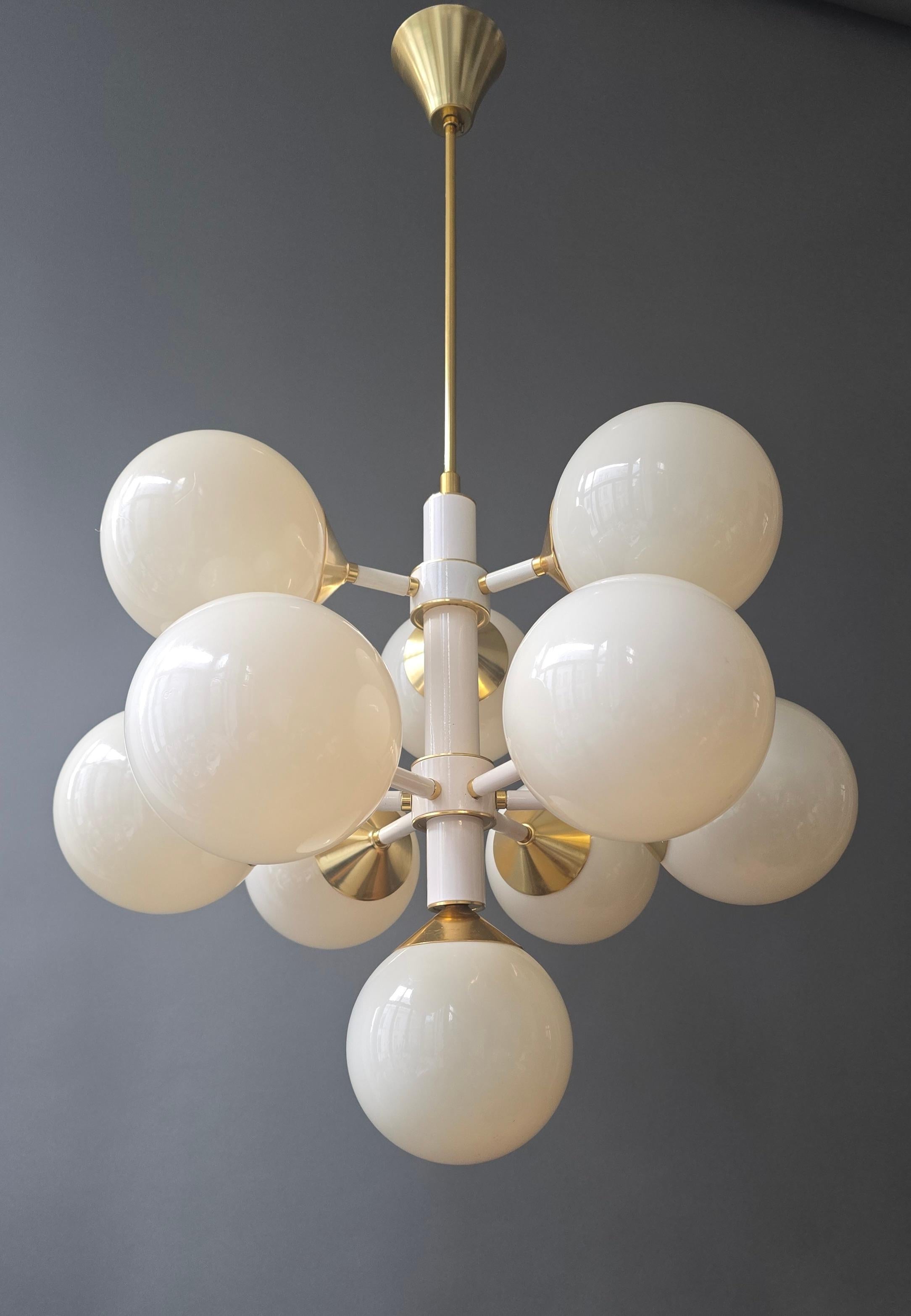 Italienischer zwölfflammiger Sputnik-Kronleuchter aus den 1970er Jahren mit großen geformten Kunststoffkugeln, weiß lackierter Struktur und Messingdetails. Durchmesser 56 cm, Höhe der Halterung 50 cm, Gesamthöhe 92 cm.

Ein auffälliger italienischer