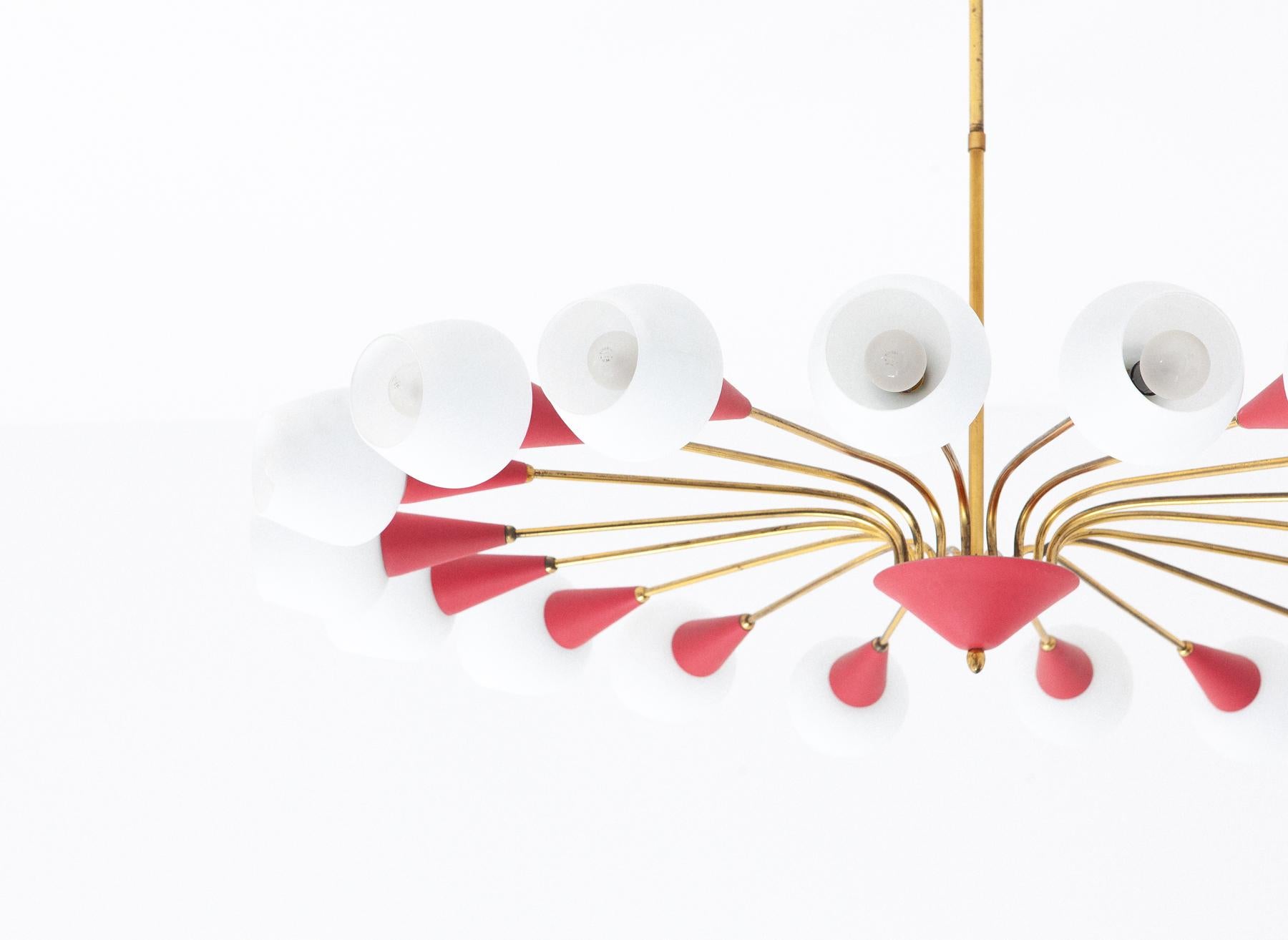 A very large eighteen-arm spider ceiling mount chandelier
A Mid-Century Modern pendant lamp manufactured in Italy in the 1950s.
Made of brass, light red painted metal and white opal glass lamp shades.

Original working wire
The lamp has 18 sockets
