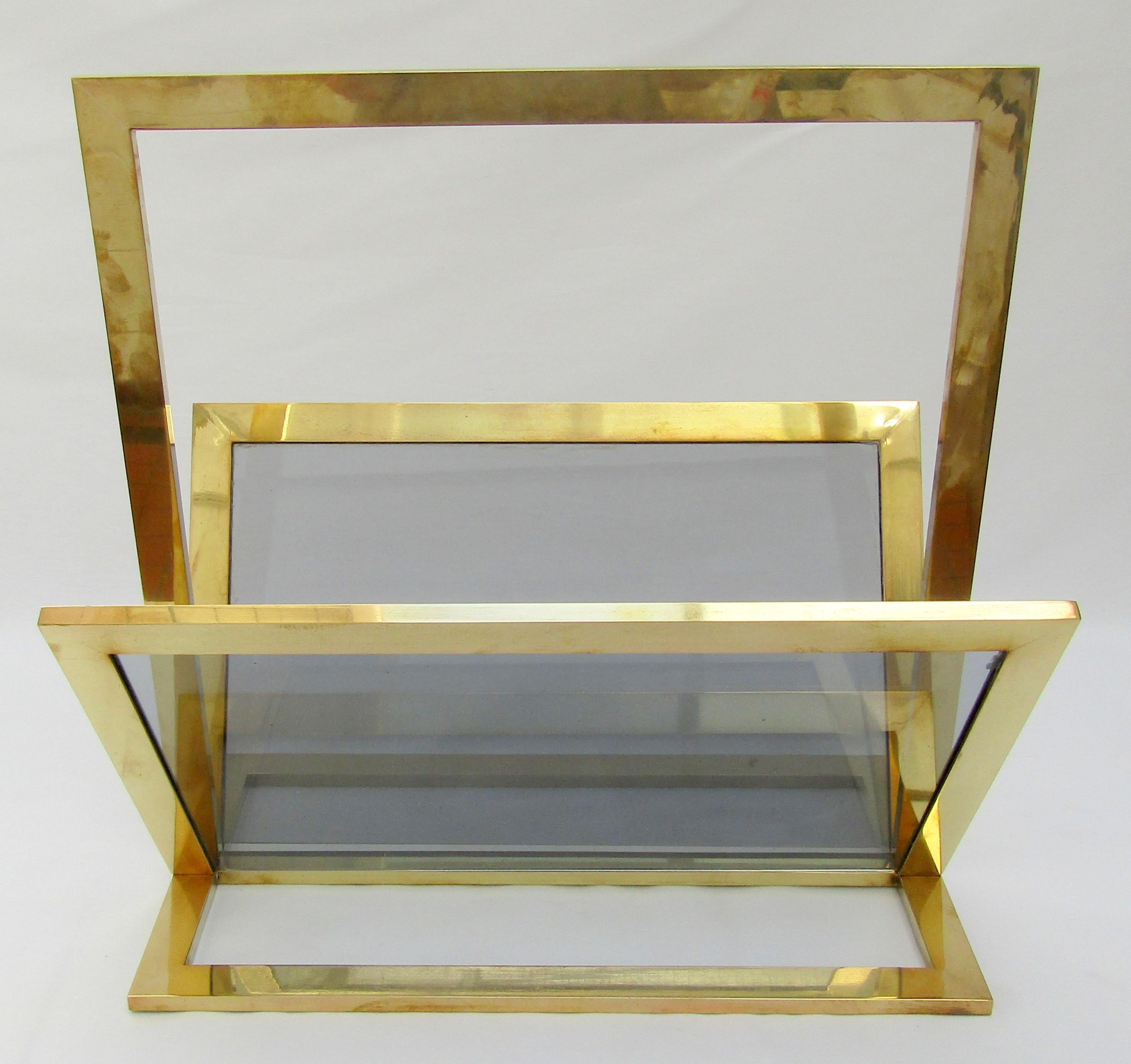 A large brass and smoked glass magazine rack
Italian, circa 1970

Measures: Height 18 in / 46 cm
Width 17 ¾ in / 45 cm
Depth 12 in / 30.5 cm.