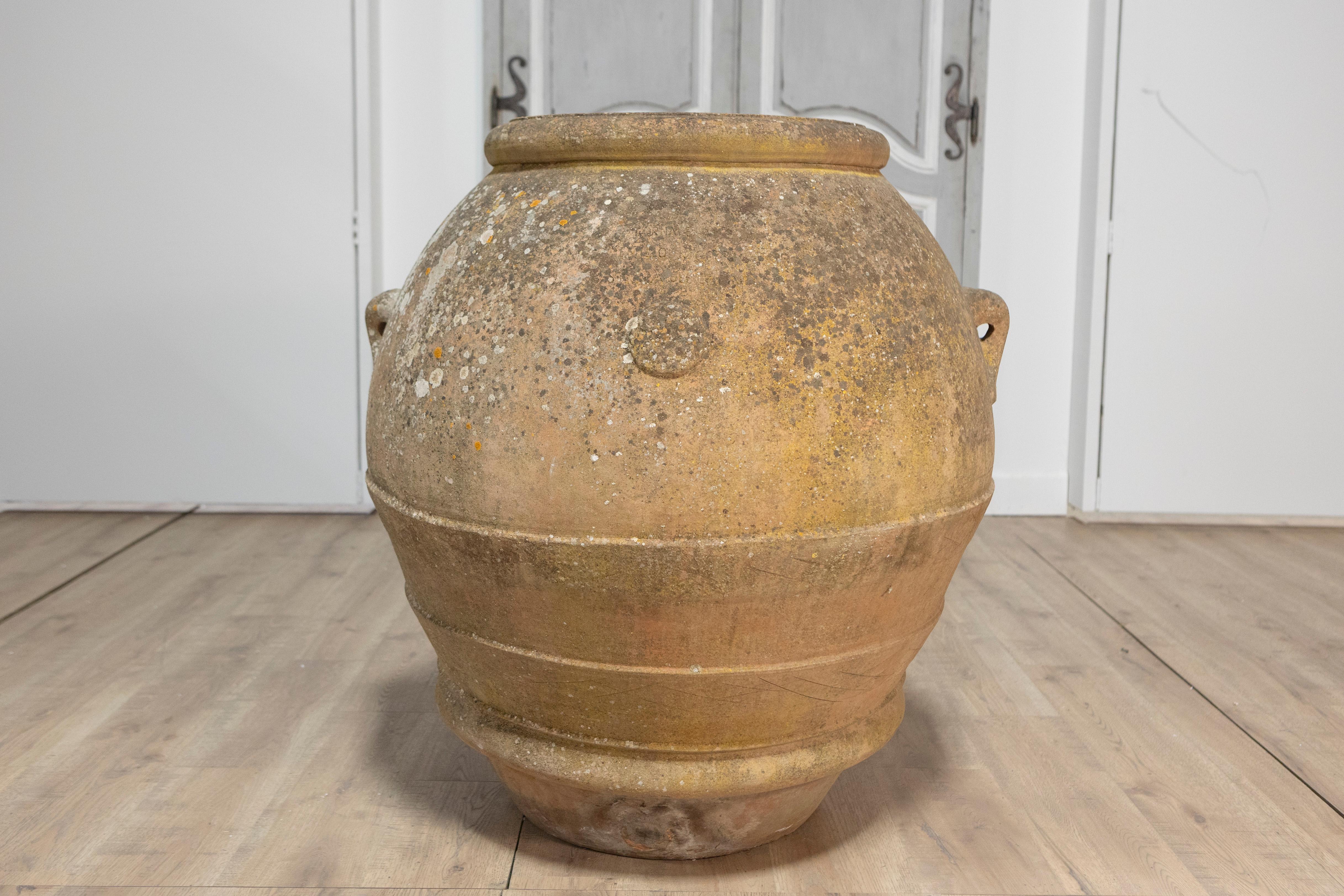 A large Italian terracotta planter from the 19th century with nicely weathered appearance and small lateral handles. This large Italian terracotta planter from the 19th century exudes rustic charm and timeless elegance. With a beautifully weathered