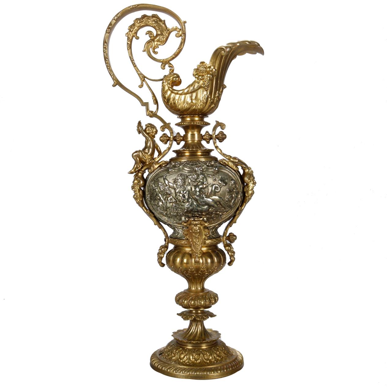 An antique and large Classical Italian Baroque lamp base offers ewer form with partial gilt bronze and white metal construction having scrolled foliate handle and stylize gilt shell form spout surmounting urn base with relief Classical Greek scene,