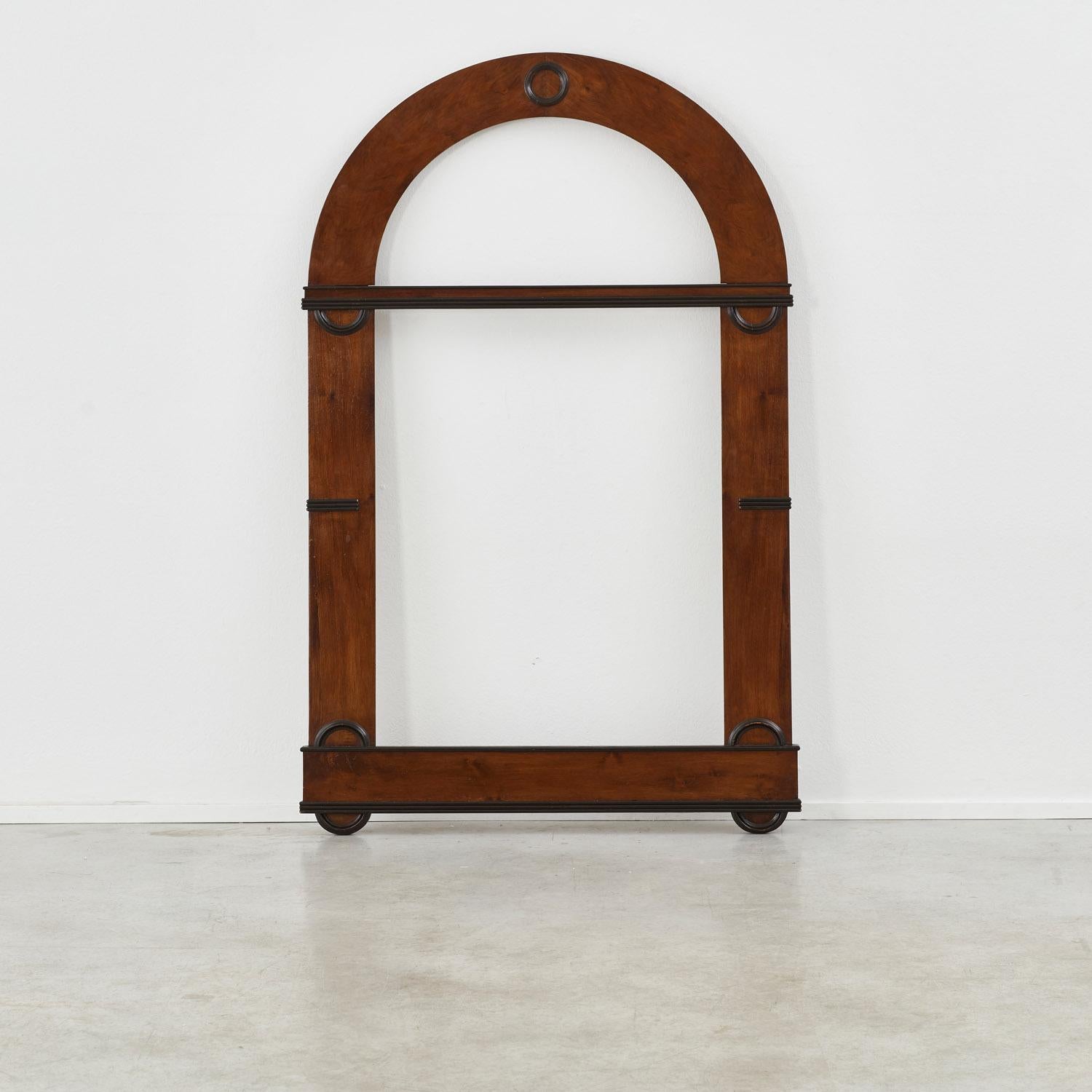 An imposing arched frame in the Biedermeier style that flourished in central Europe in the first half of the 19th century. Its restrained ornamentation is typical of the movement, which heralded Art Deco in geometric forms and simplified classic