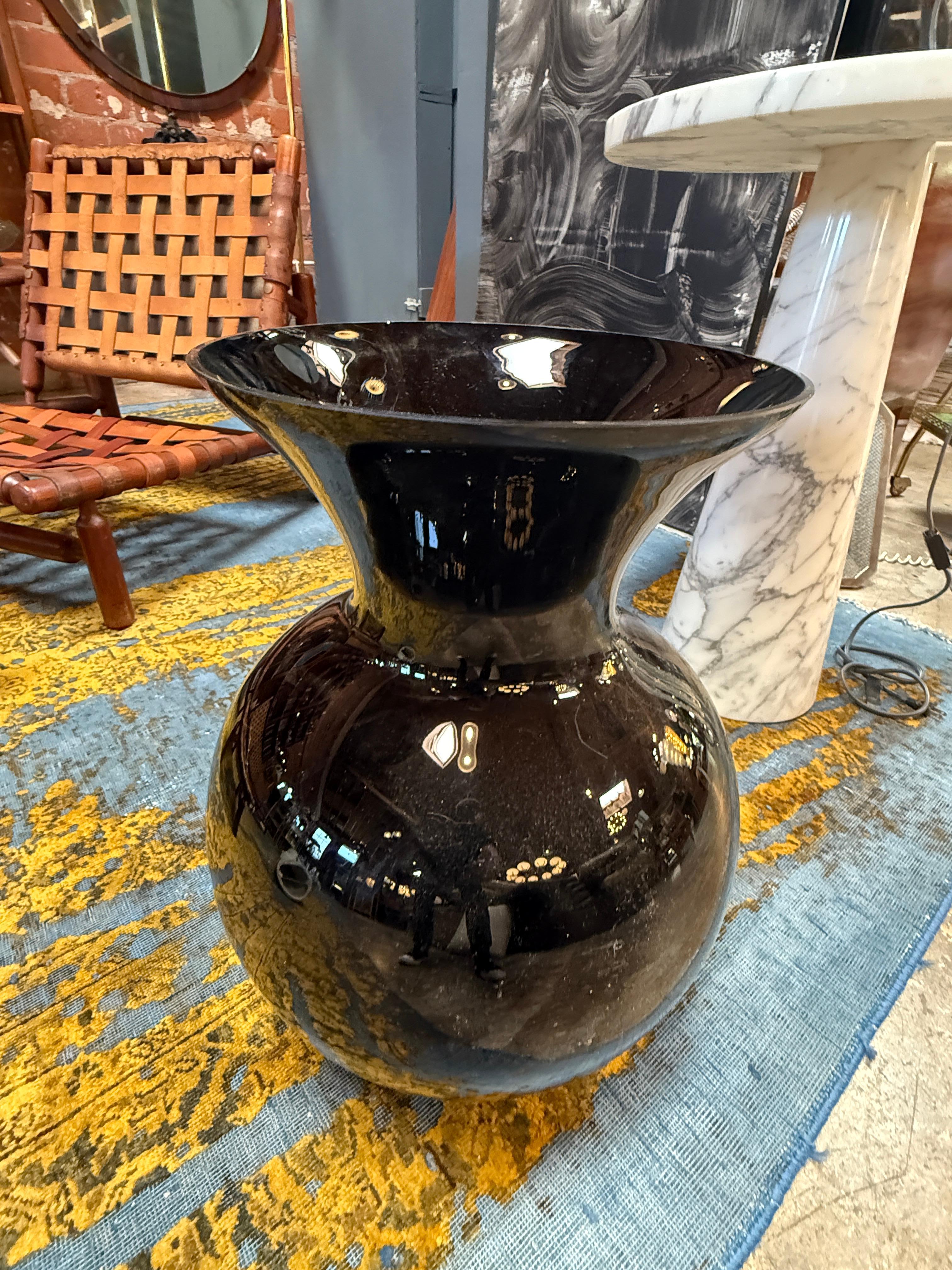 Eine auffällige, übergroße Vase aus Murano-Glas in tiefem, glänzendem Schwarz. Seine kühne Silhouette hat eine abgerundete Basis, die sich anmutig verjüngt, bevor sie in eine weite, offene Öffnung mündet, was ihm eine skulpturale und dramatische
