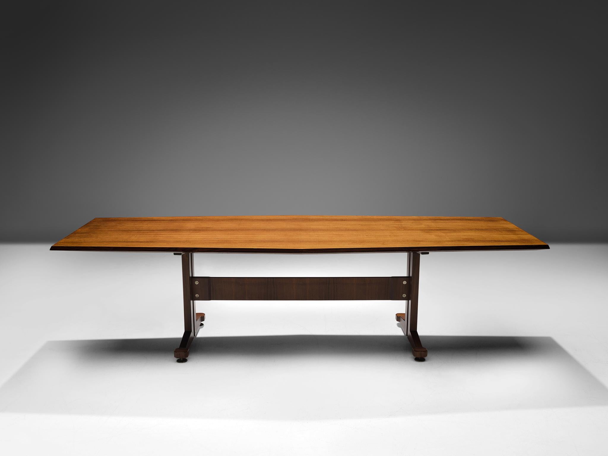 Dining table or conference table, teak, metal, Italy, 1960s.

This large boat-shaped dining or conference table has a teak wood top which shows the beautiful grain of the material. This lays on a construction in a functionalist style. Metal details
