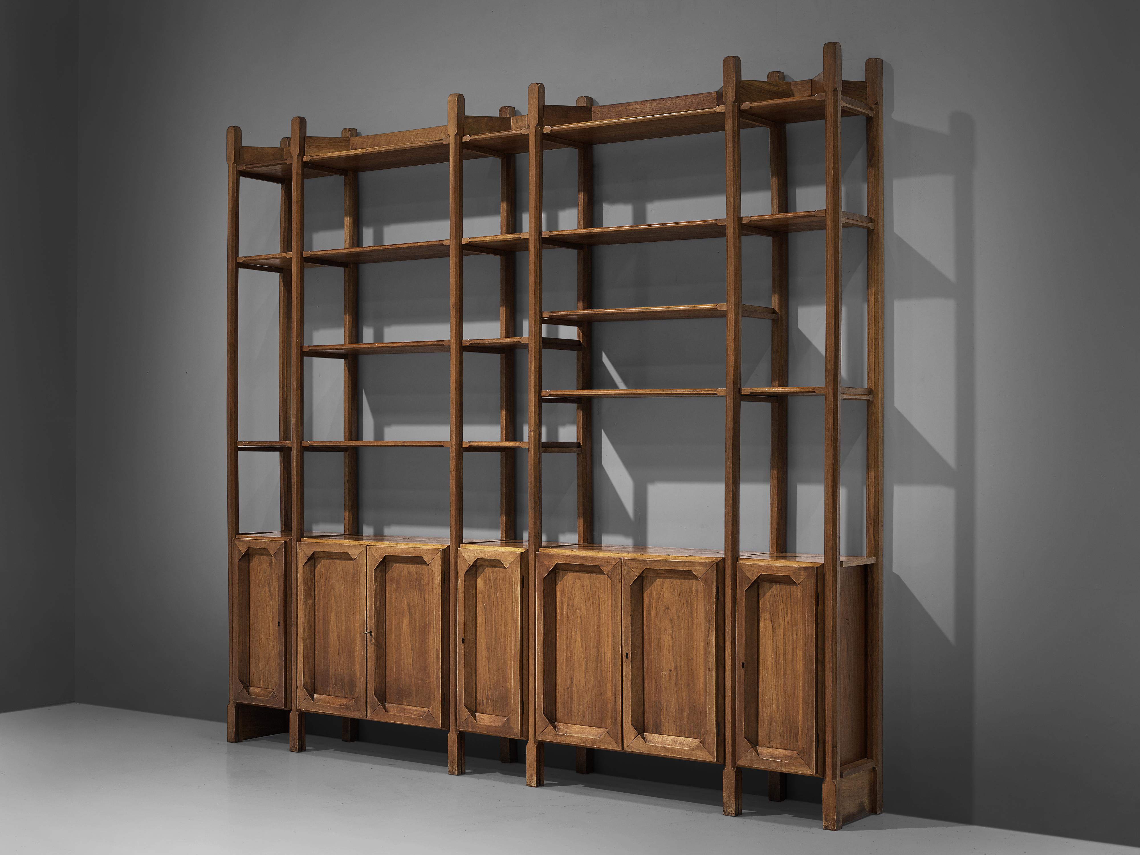 Bookcase, walnut, brass, Italy, 1960s

Wonderful Italian open bookcase with five cabinets. All elements feature carved details that contribute to the sculptural and grand expression of the shelf. Five columns in two widths all start with a cabinet