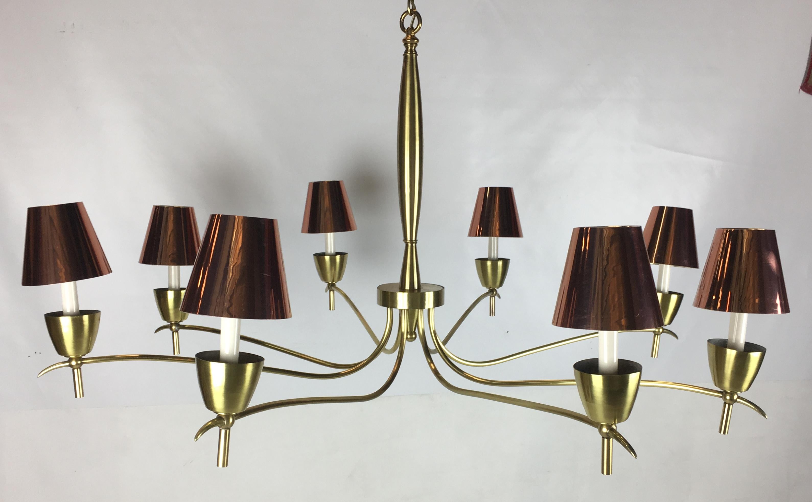 Spectacular brass chandelier with eight undulating arms. The piece has been completely restored with each element hand polished and lacquered before being rewired. The shades are not original to the chandelier and can be used or not.