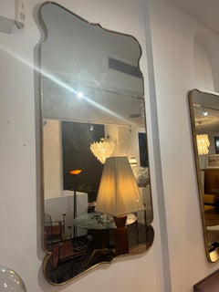 Large Italian brass framed mirror in the style of Gio Ponti .