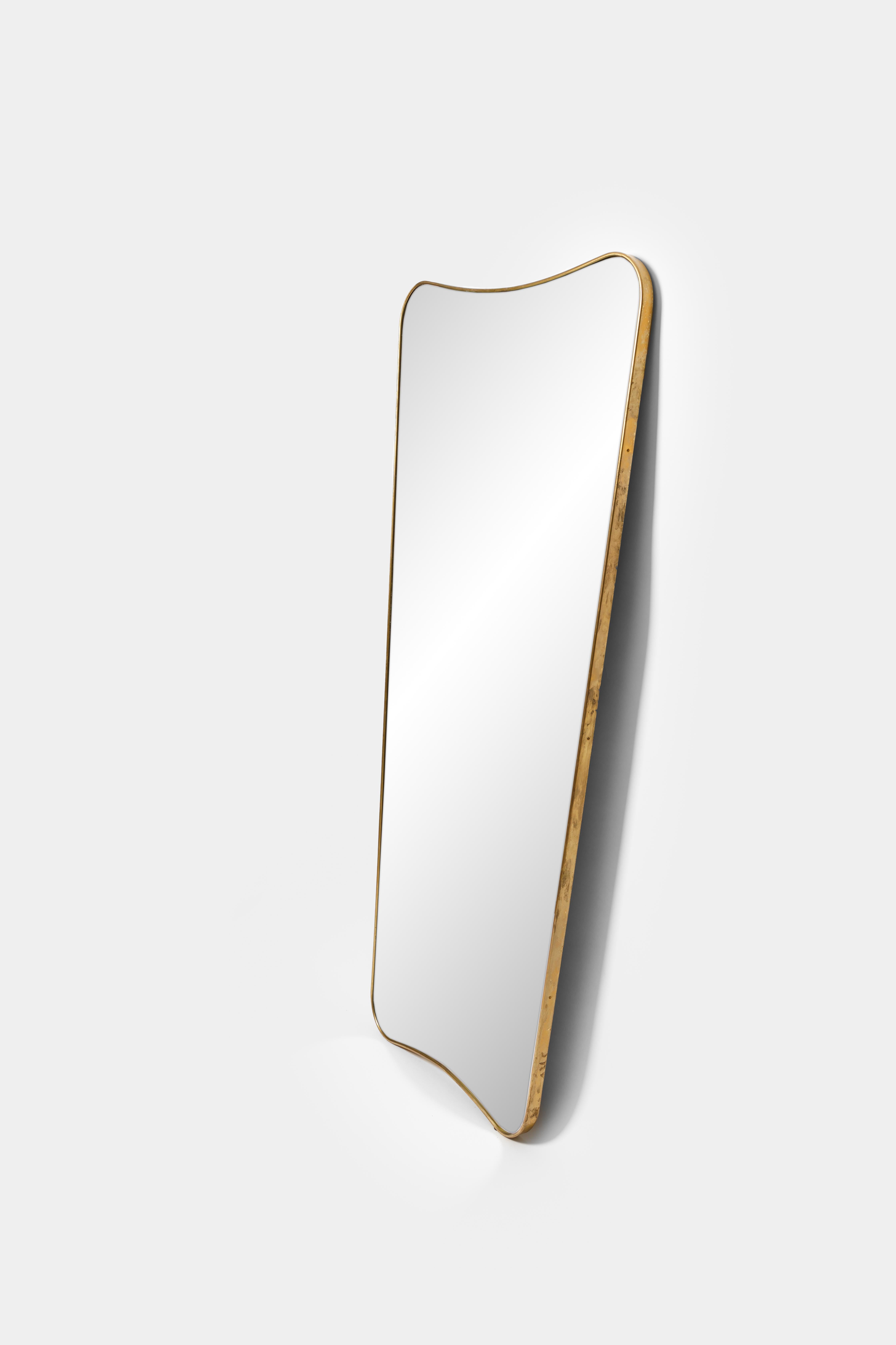 Elegant and large brass framed mirror with gently curved form. Beautifully patinated brass frame and solid construction with wood backing, Italy, 1990s.
         
