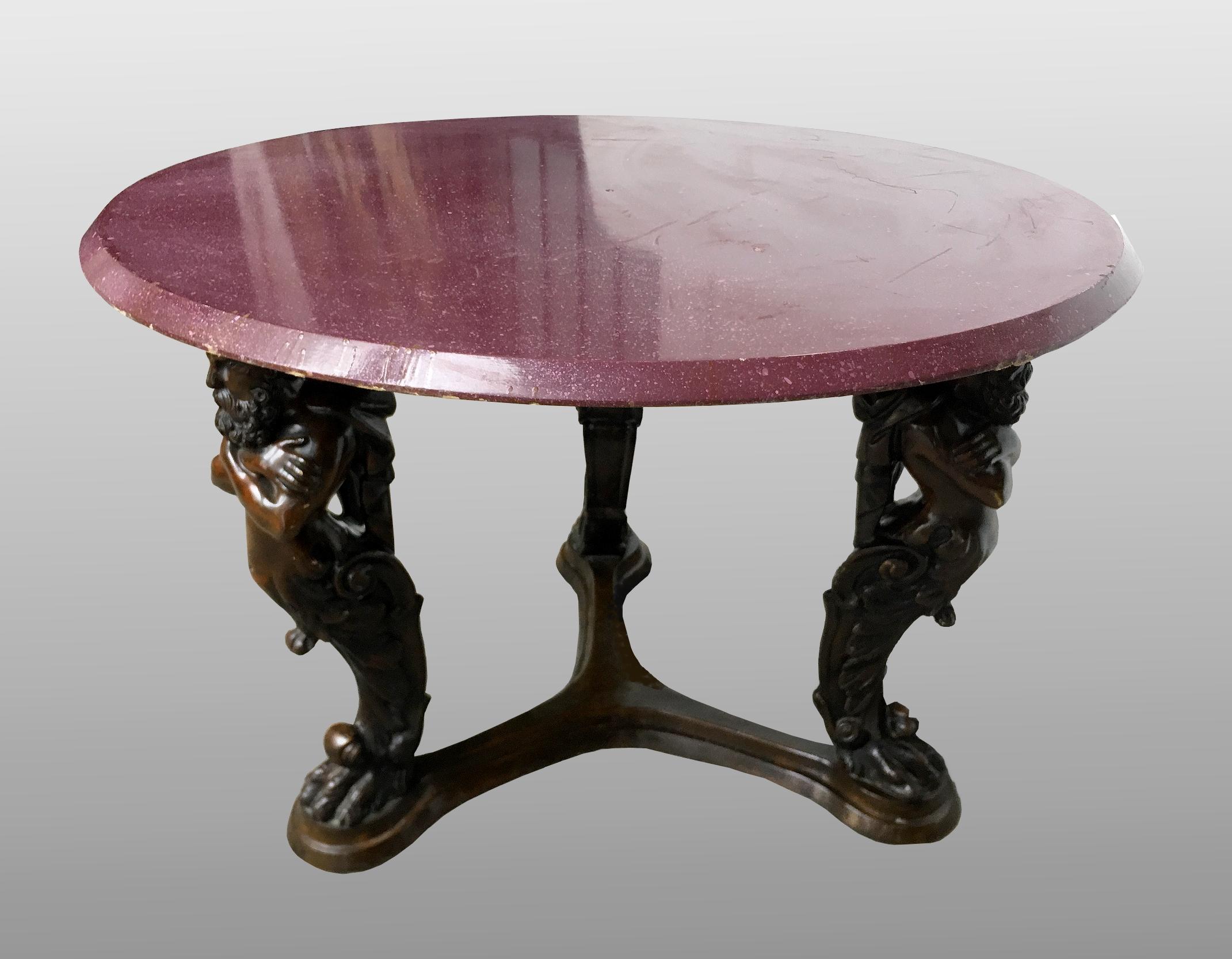 Large Italian bronze pedestal table, top painted in imitation of porphyry. The neoclassical bronze tripod base features three caryatids with the faces of bearded emperors connected by a molded spacer. The top is in wood, painted in trompe-l'oeil in