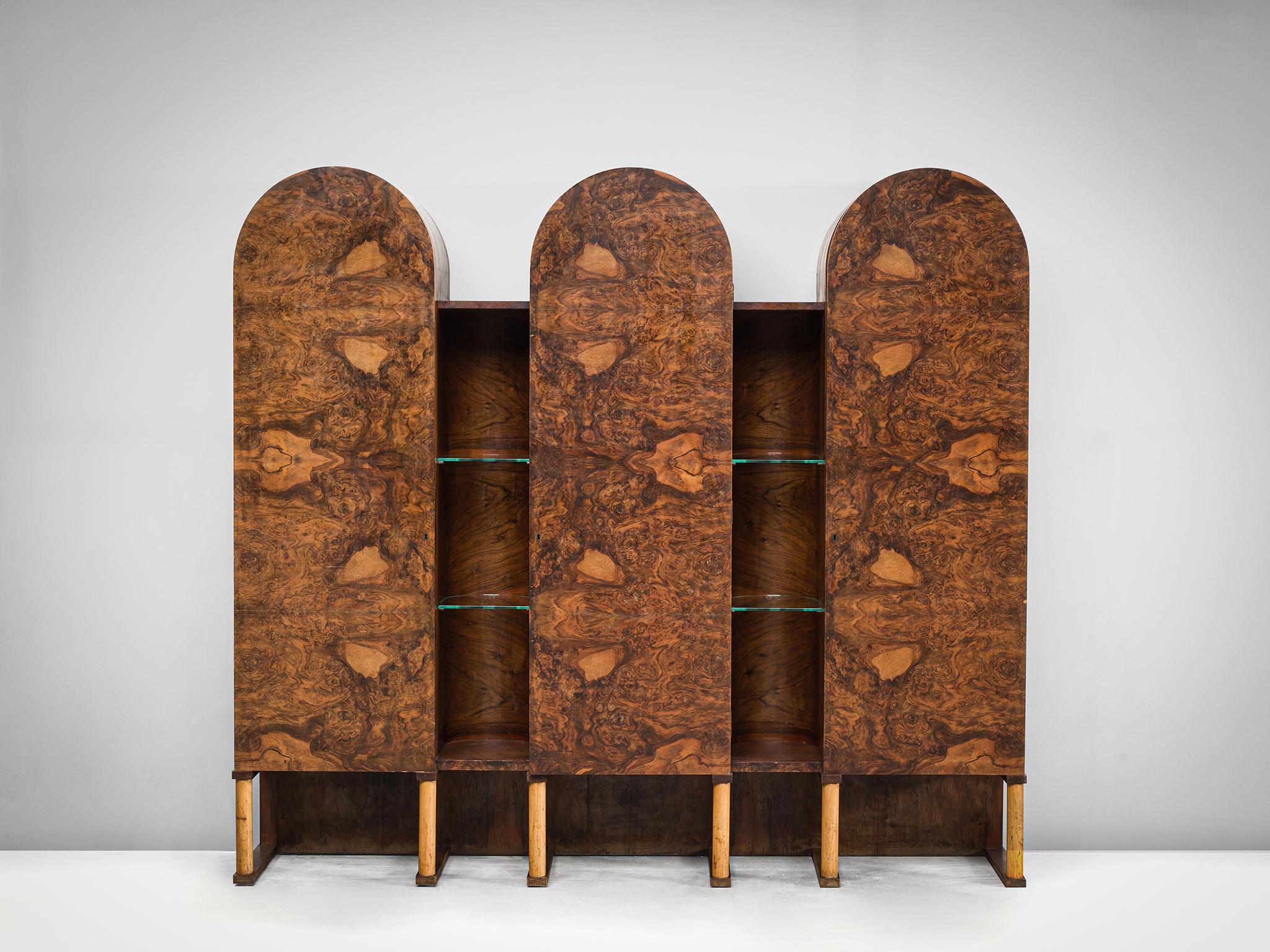Cabinet, walnut burl, wood, glass, Italy, 1960s.

This sensuous cabinet is executed in walnut burl. The cabinet features three arches with three burl doors, and four shelves. In between the arches are open gaps with featuring two glass shelves. The