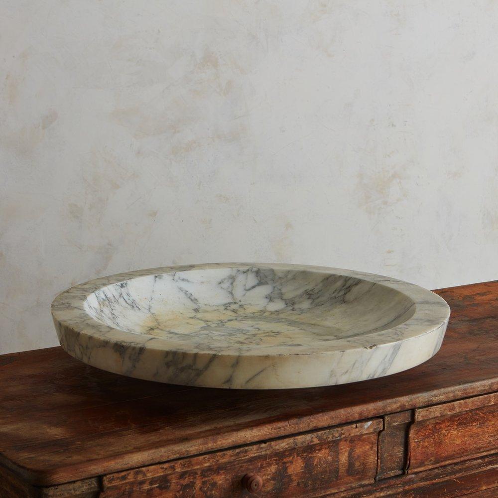 An oversized antique Italian centerpiece bowl constructed from Calacatta marble with gorgeous gray and white veining. This bowl has a pedestal base and a stately presence, perfect for styling fruit or flowers. Sourced in Italy, 18th century.

.