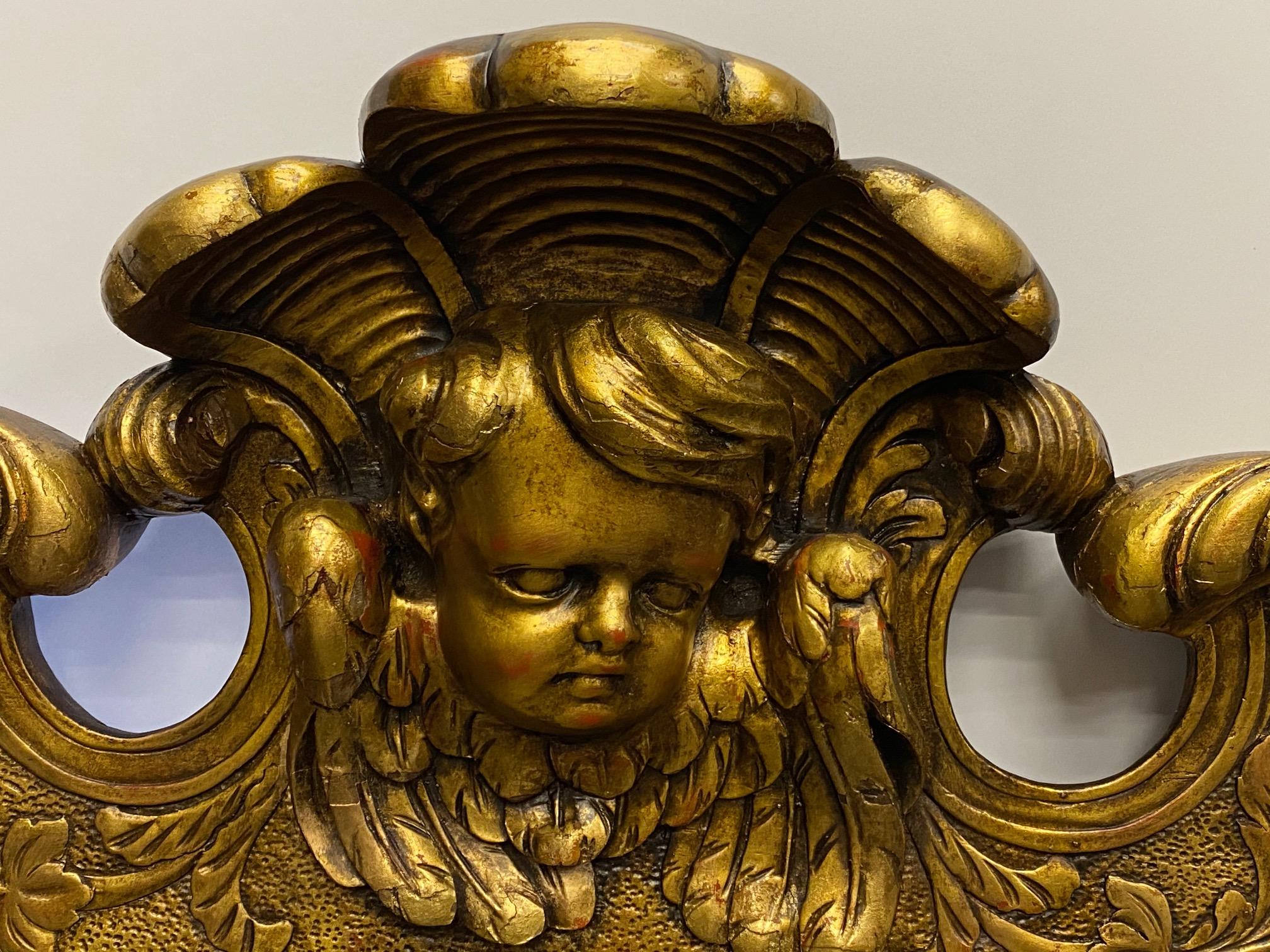 Magnifique miroir vintage en noyer sculpté avec une finition en or vénitien, de merveilleux détails à la sculpture et le visage d'un chérubin au sommet.
Profondeur du corps du miroir : 1/5