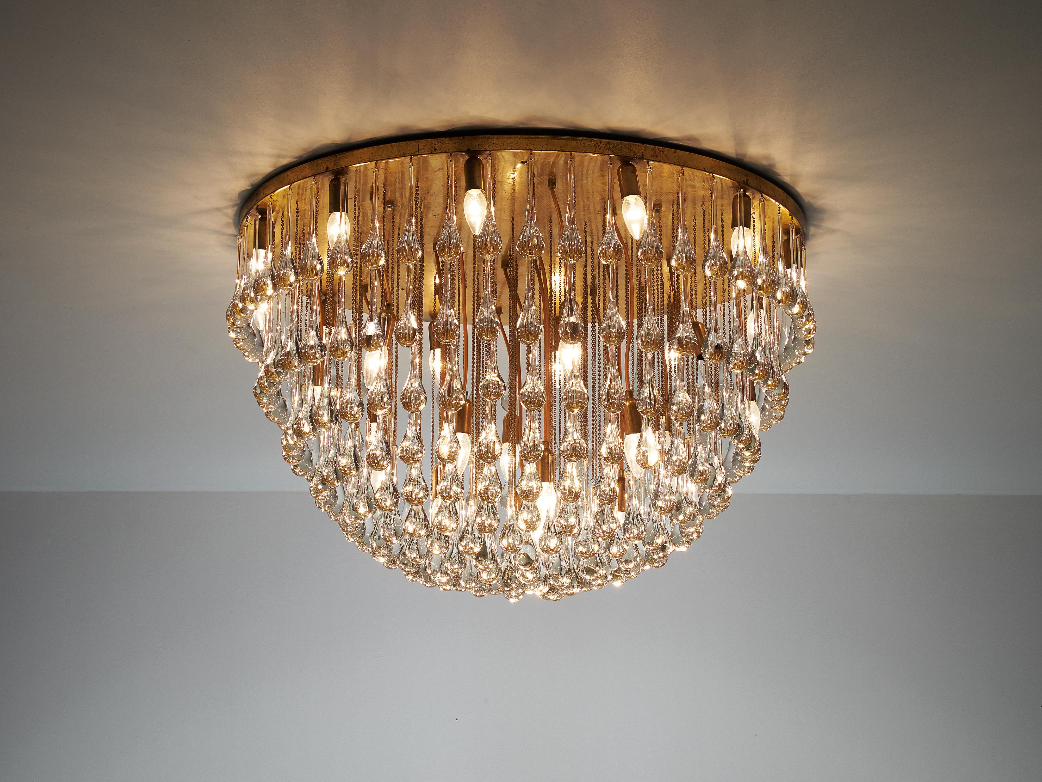 Chandelier, brass, glass, Italy, 1960s

Majestic Italian chandelier with a large amount of glass drops. This noble lamp creates a stunning light partition. The glass drops positioned on different heights combine together into a large globe. In