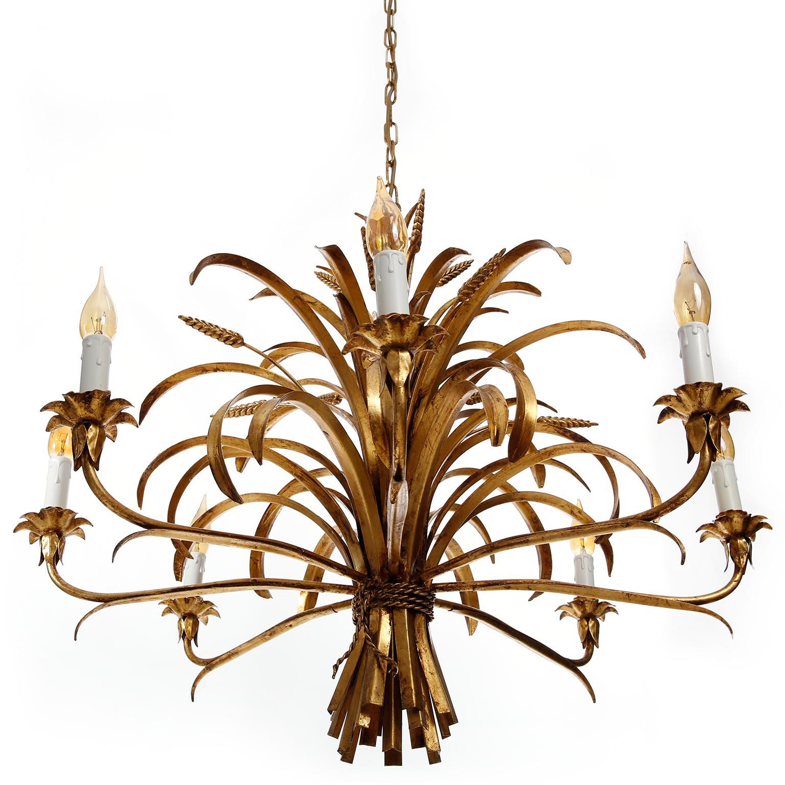 A large Hollywood Regency eight-arm light fixture from Italy manufactured in midcentury (1960s-1970s). It is in the form of a bunch of wheat sheafs and it is made of antique leaf gold plated metal. The lamp has eight sockets for small screw base