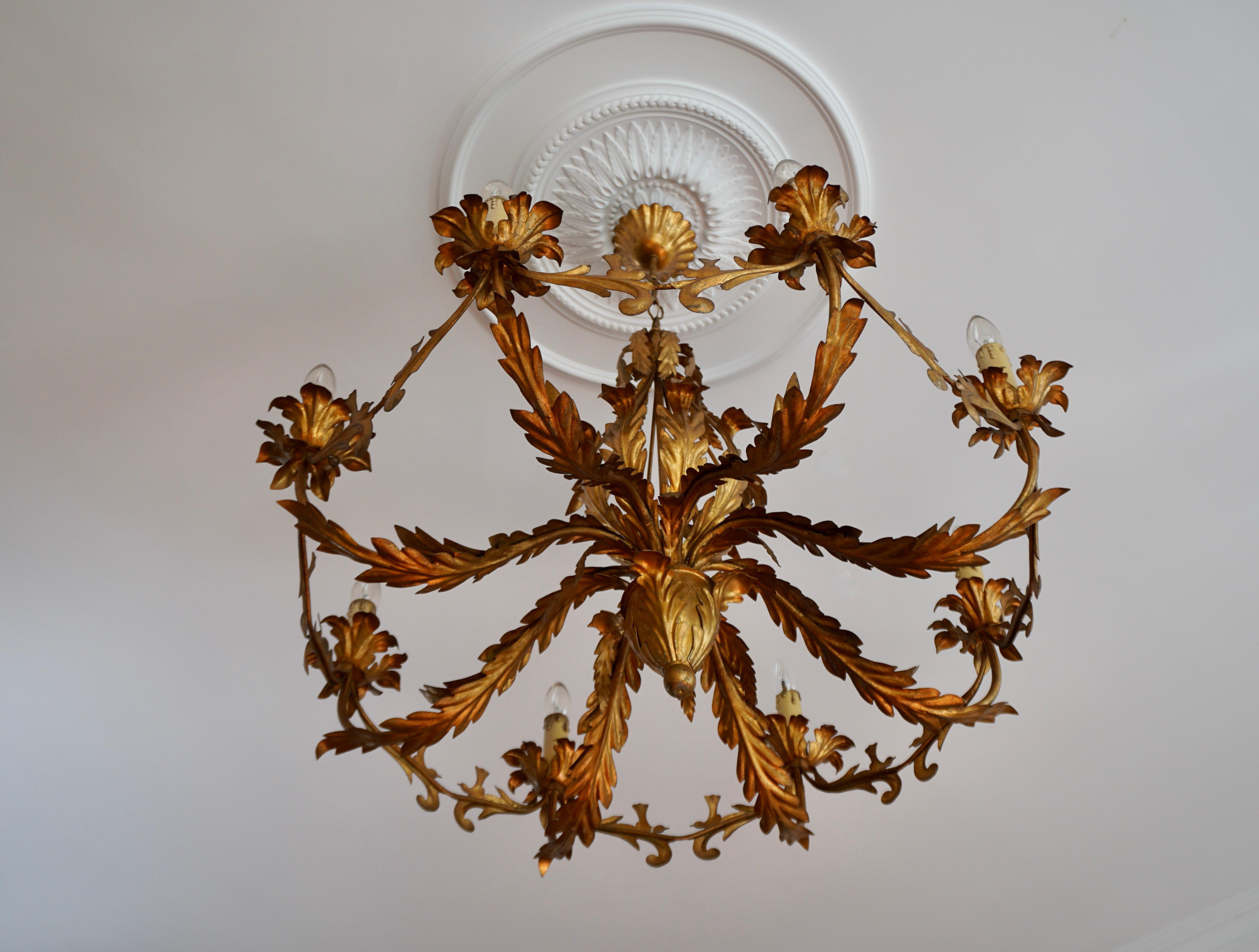 A large Hollywood Regency Coco Chanel style eight-arm light fixture from Italy manufactured in midcentury (1960s-1970s). 

The lamp has eight sockets for small screw base bulbs or LEDs type E14. It also can be used with a dimmer. 
The height of