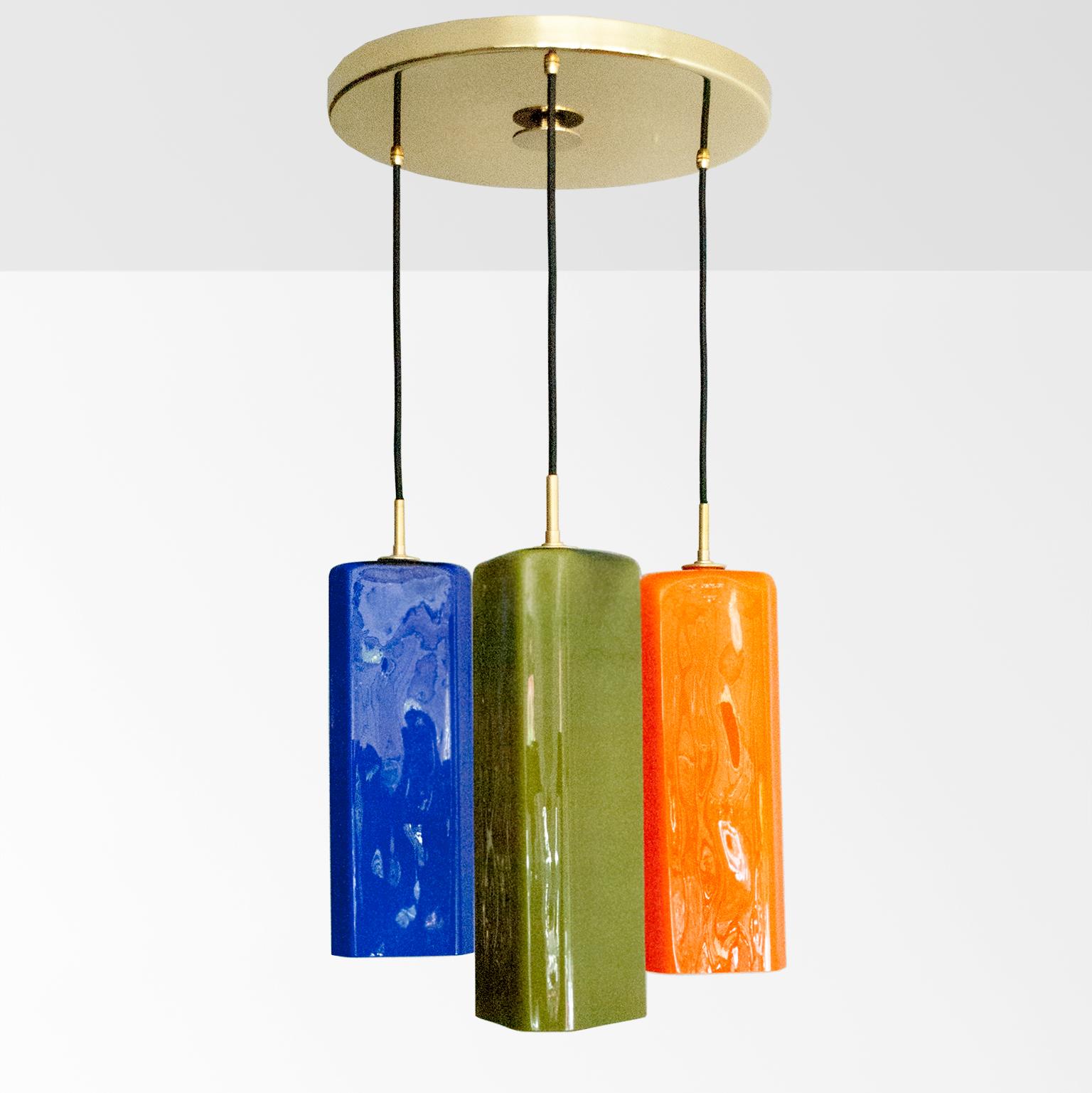 Large Italian, probably Vistosi, chandelier with three jewel colored glass shades. The cased glass shades have white interiors are triangular shaped with softly rounded corners. A large 15