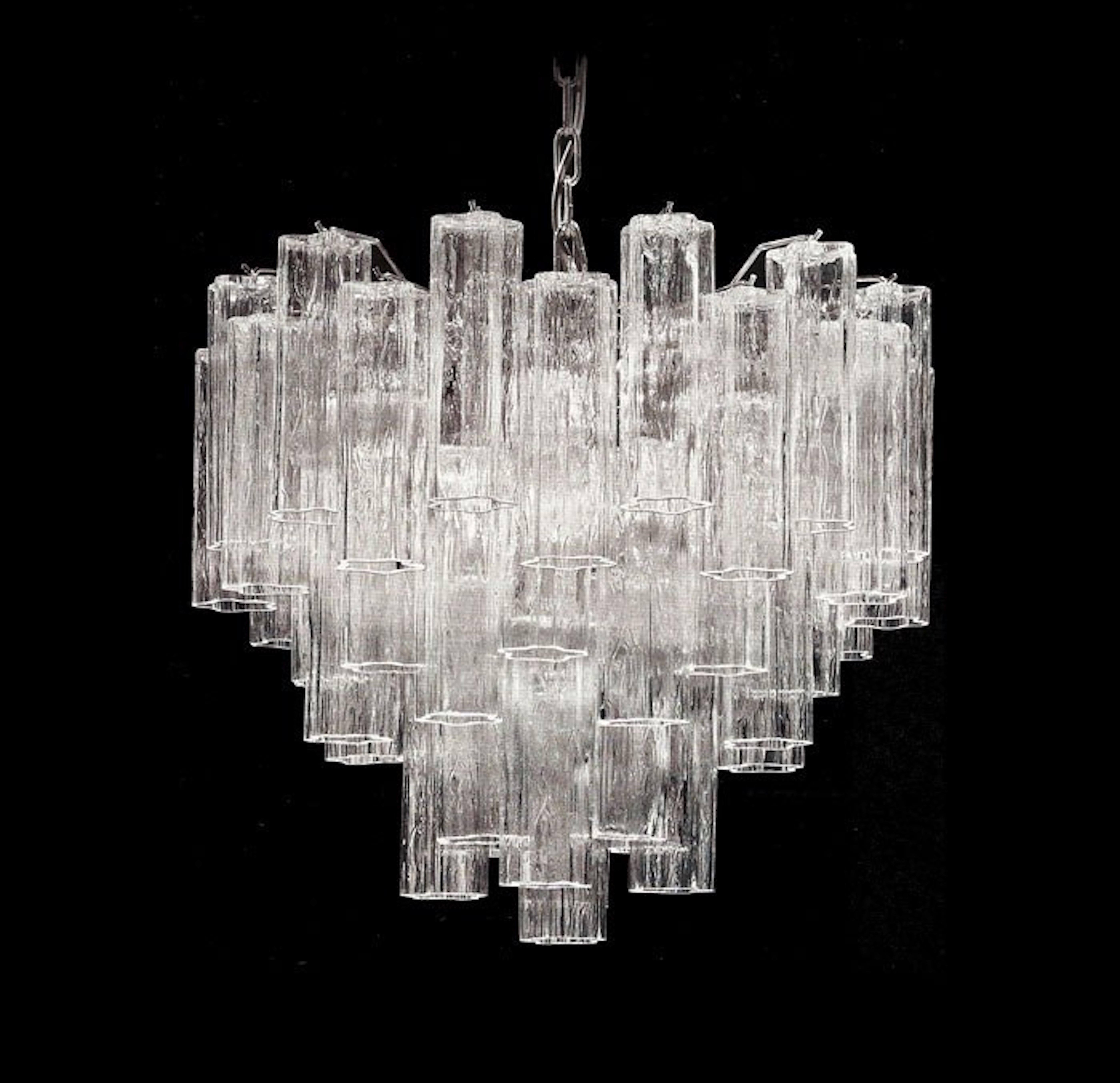 
Spectacular, Multi-Tiered Chandelier composed of a series of delicate glass drops with undulating sections, producing a wonderfully rich and mellow light.
Frame can be ordered in chrome or gold. Glass drops are also available in amber and rich pink