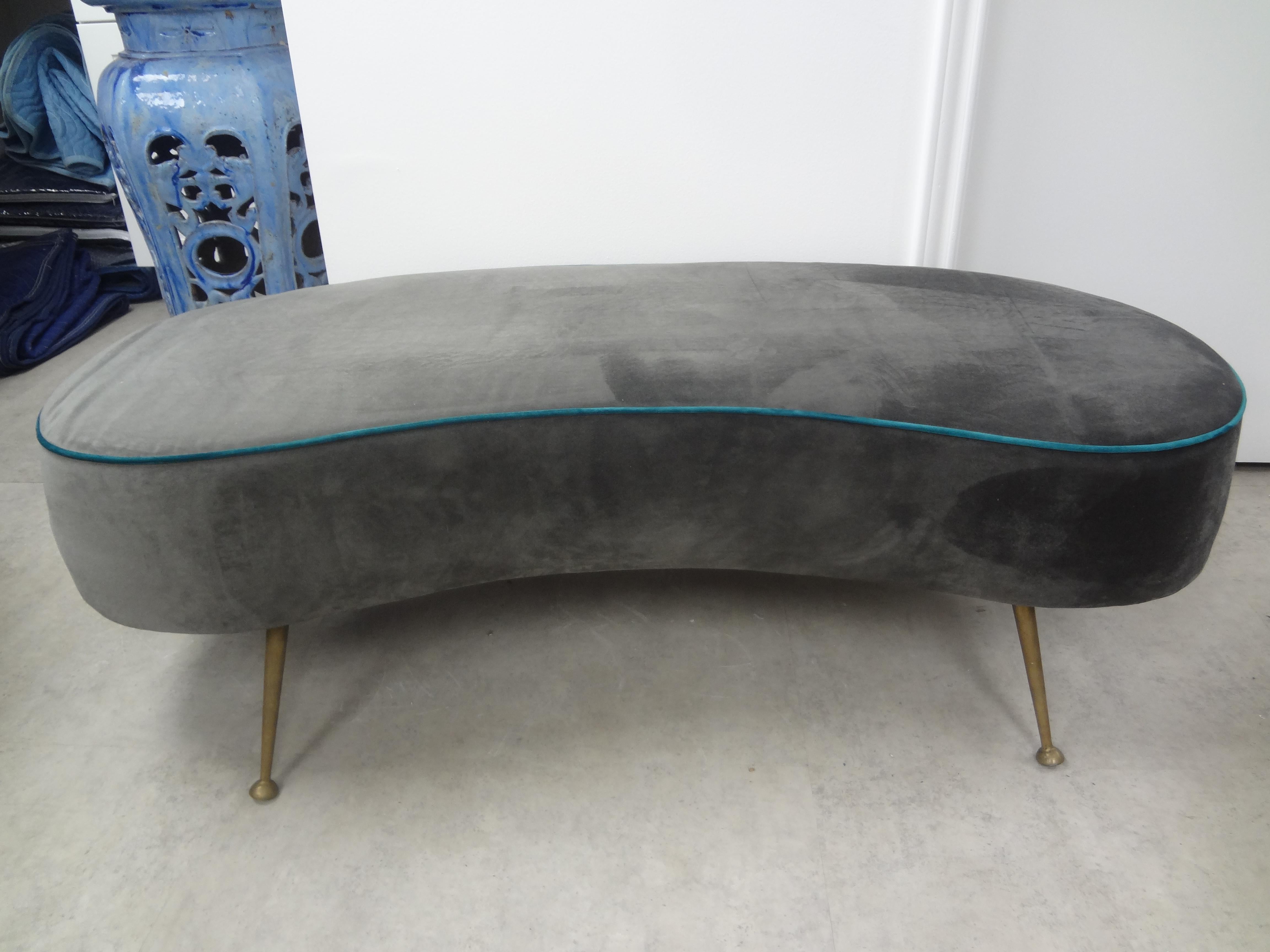 Large Italian Gio Ponti style curved bench with brass legs.
Large Italian curved bench with splayed brass legs. This stunning Italian modern Gio Ponti inspired bench is upholstered in grey velvet with turquoise piping. Easy to re-upholster in the