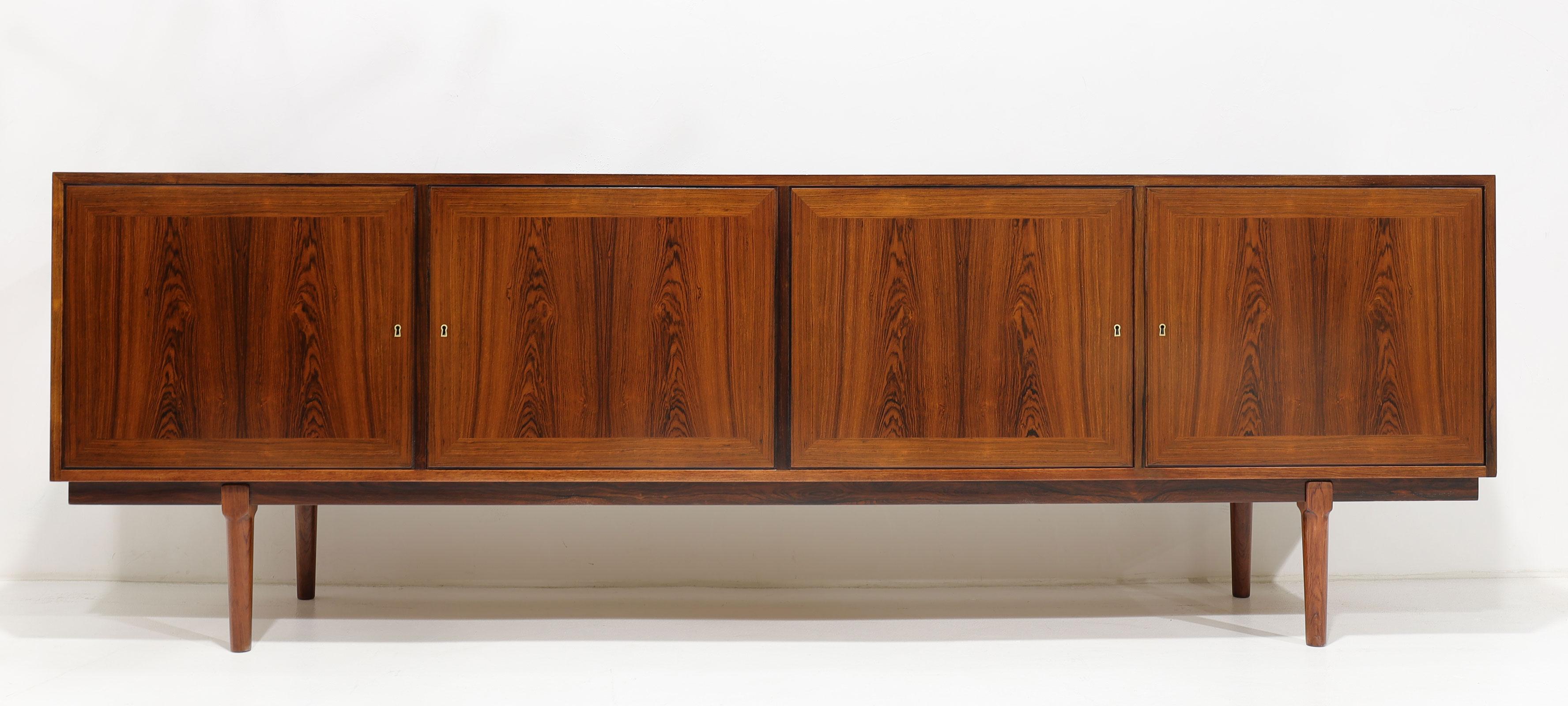 This is a beautiful sideboard with four doors in front with book matched rosewood and a framed surround on each door. We have three keys, but keys are interchangeable. They are brass as are the keyholes. Interior features two drawers and four felt