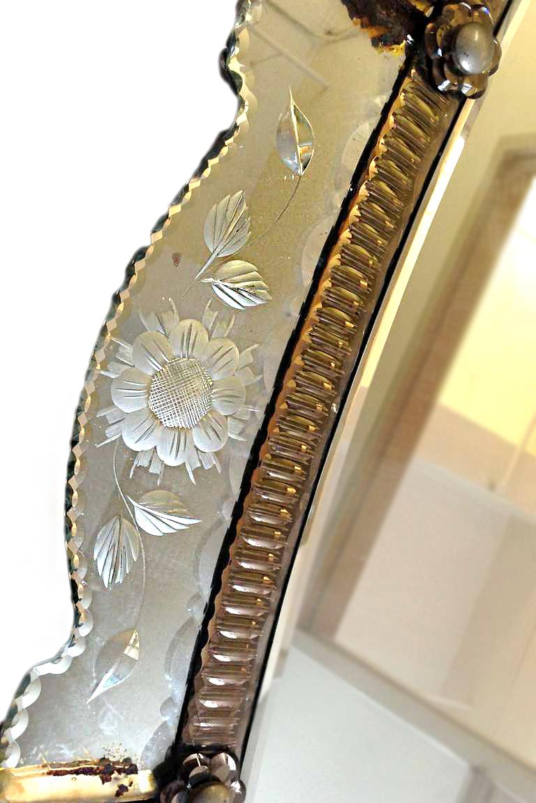 A large, Venetian circa 1930's oval mirror with etched flowers and foliage motif on frame, the frame with a slightly smoked color around the looking glass.

Measurements:
Height: 78