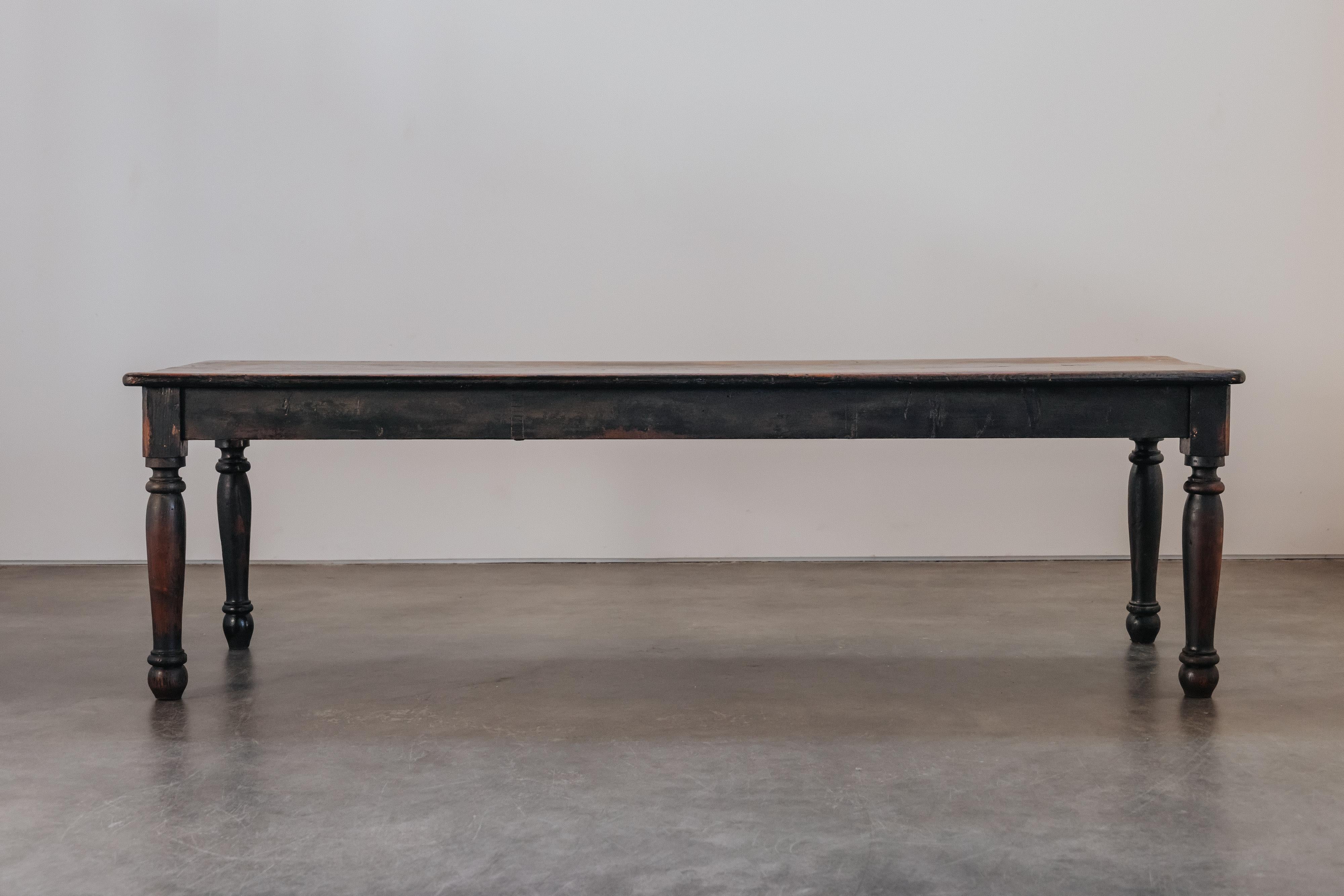 Grande table de ferme italienne provenant de France, vers 1850.  Construction en pin massif avec peinture noire d'origine.  Très belle patine et utilisation.