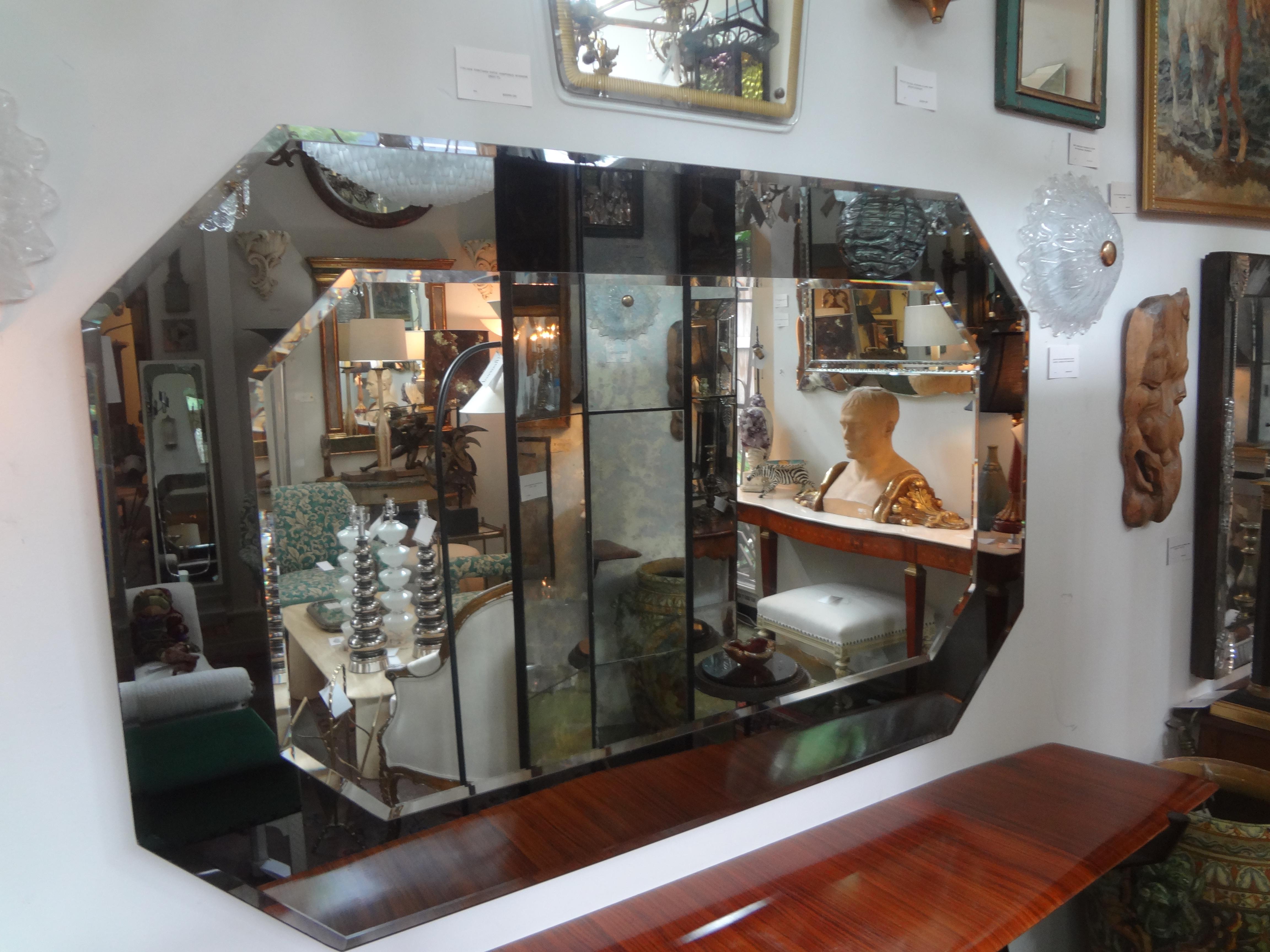 Large Italian Fontana Arte style horizontal beveled mirror.
Stunning Italian Max Ingrand for Fontana Arte style horizontal octagonal mirror. This fabulous mirror is totally beveled and has a dark glass perimeter and silver central section. Our