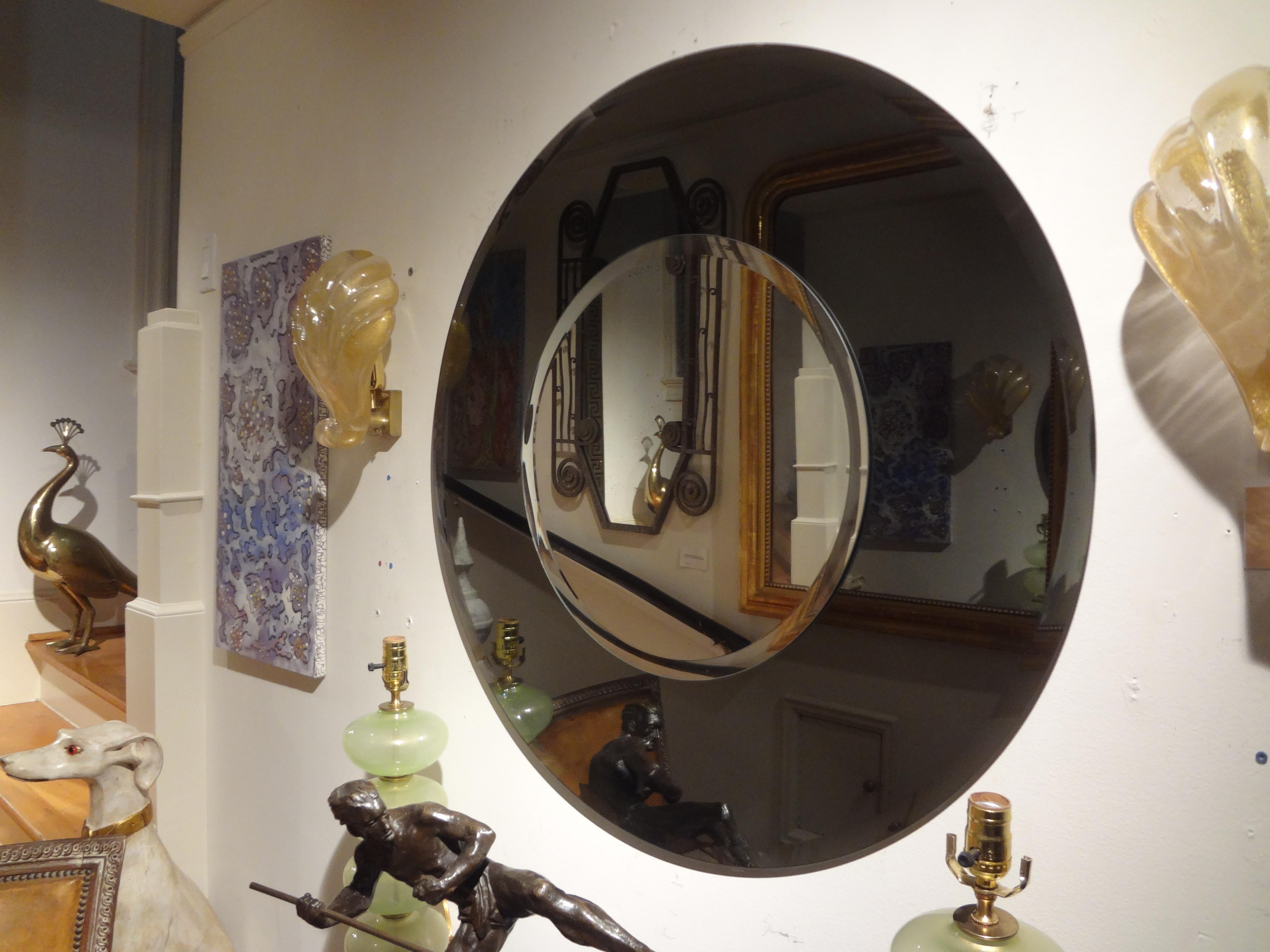 Large Italian Fontana Arte style round beveled mirror.
Stunning large round Italian Fontana Arte inspired round beveled mirror. This beautiful Mid-Century Modern Italian mirror has a black beveled perimeter with a silver beveled central
