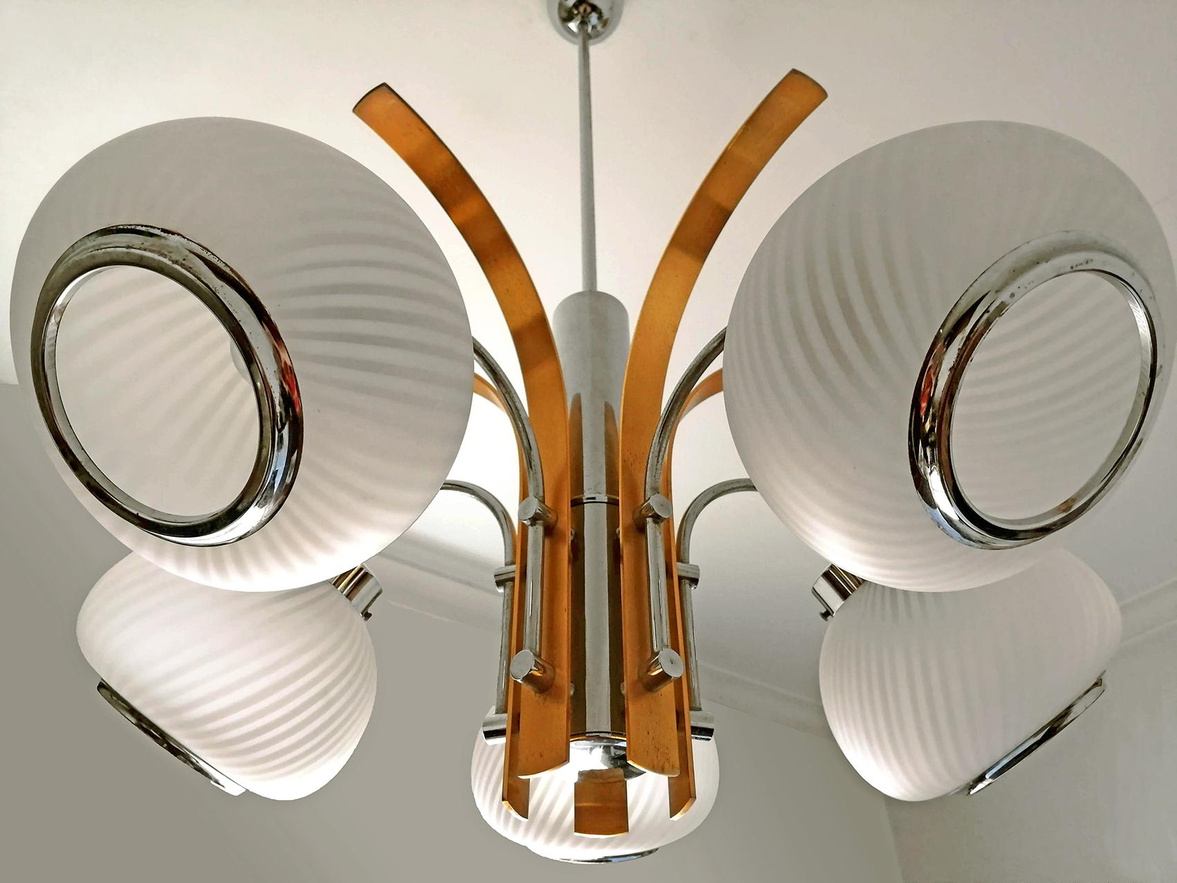 Les cinq lampes de ce lustre sont dotées de grands abat-jour géométriques en verre blanc opaque, de bras en chrome et de palmiers en laiton doré le long de l'axe central dans le style de l'Arredoluce. Fabriqué par Tappital, Italie.
Mesures