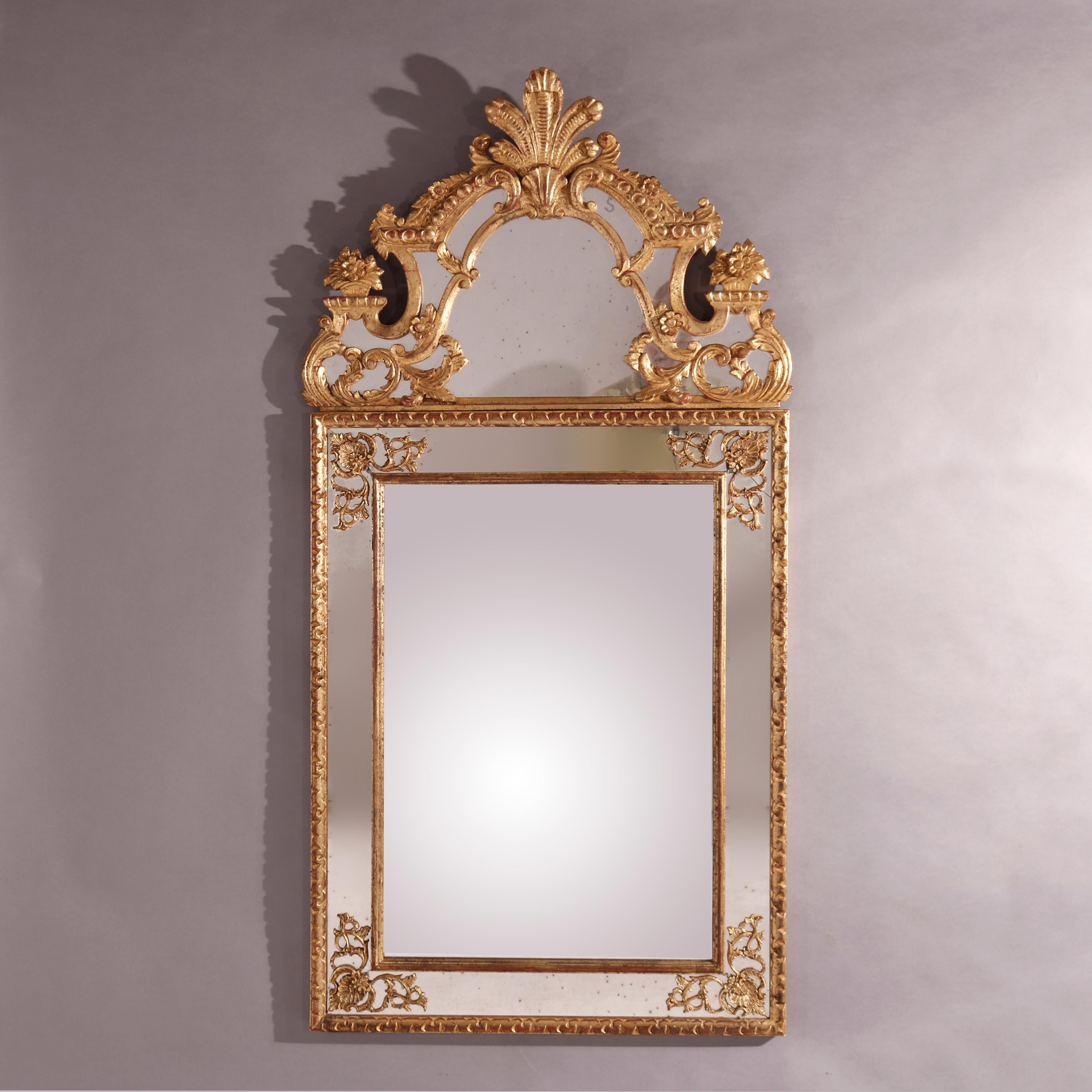 An oversized Italian over mantel parclose wall mirror offers giltwood construction in arched form with fleur de lis foliate and floral, scroll and foliate elements throughout, 20th century.
Measures - 60