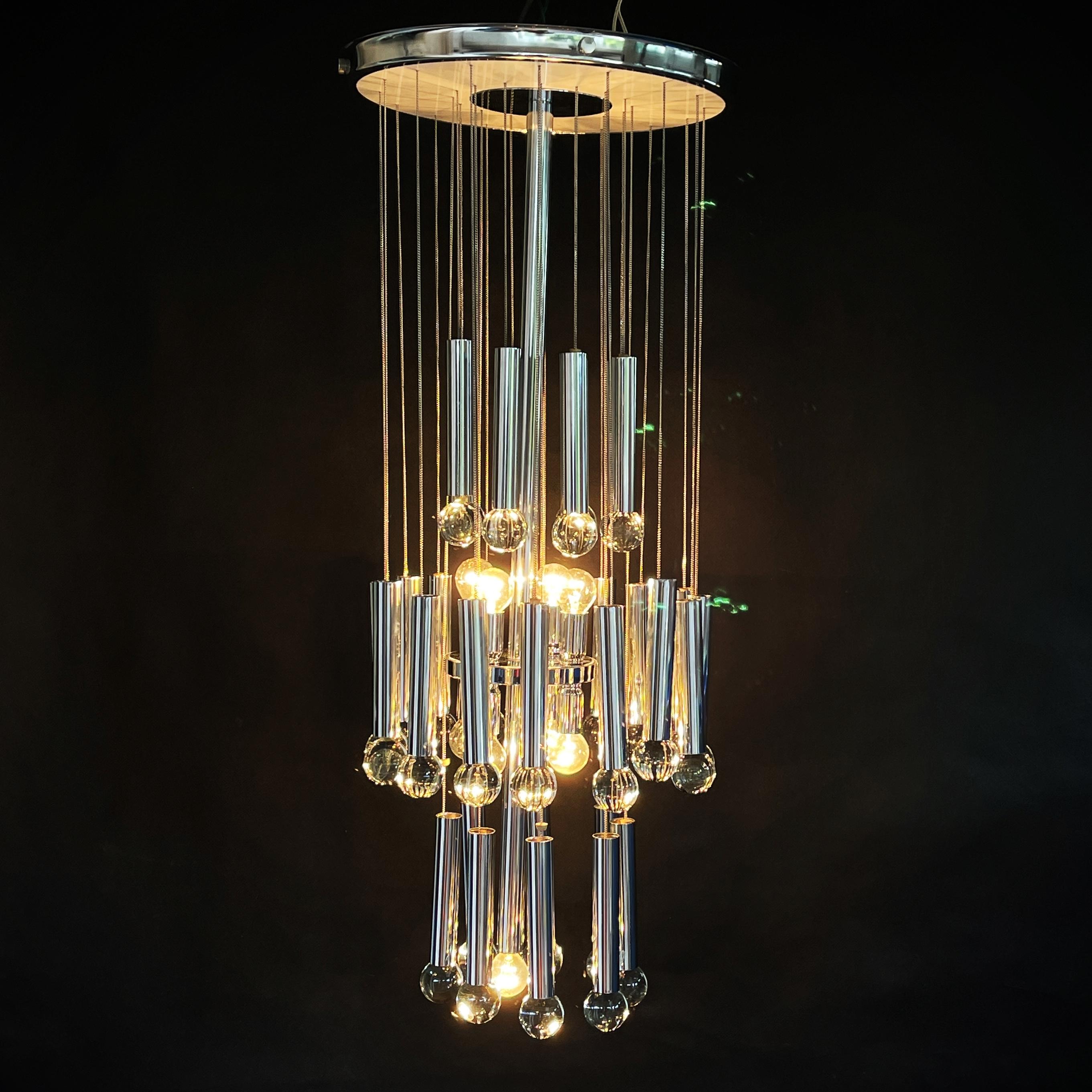 Beautiful Italian chandelier from the 1960s by Gaetano Sciolari.
The chromed frame carries 32 chains with chromed tubes and crystal balls that make a great chandelier.

The hanging lamp is an original and gives a pleasant light.

The lamp has 9