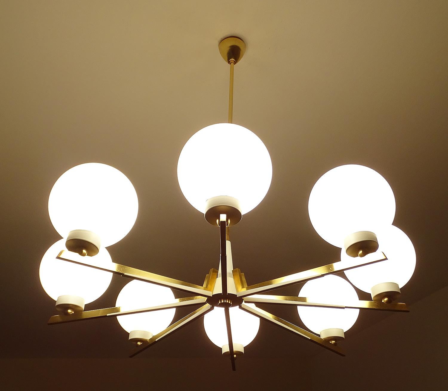 Large Original 1950s chandelier in the manner of Stilnovo,  white enameled arms with brass trim, opaline glass diffusers.
Dimensions
Height 30.71 in. x diameter 26.78 in.
Height 78 cm x diameter 68 cm
Eight candelabra size bulbs, 40 watts each.