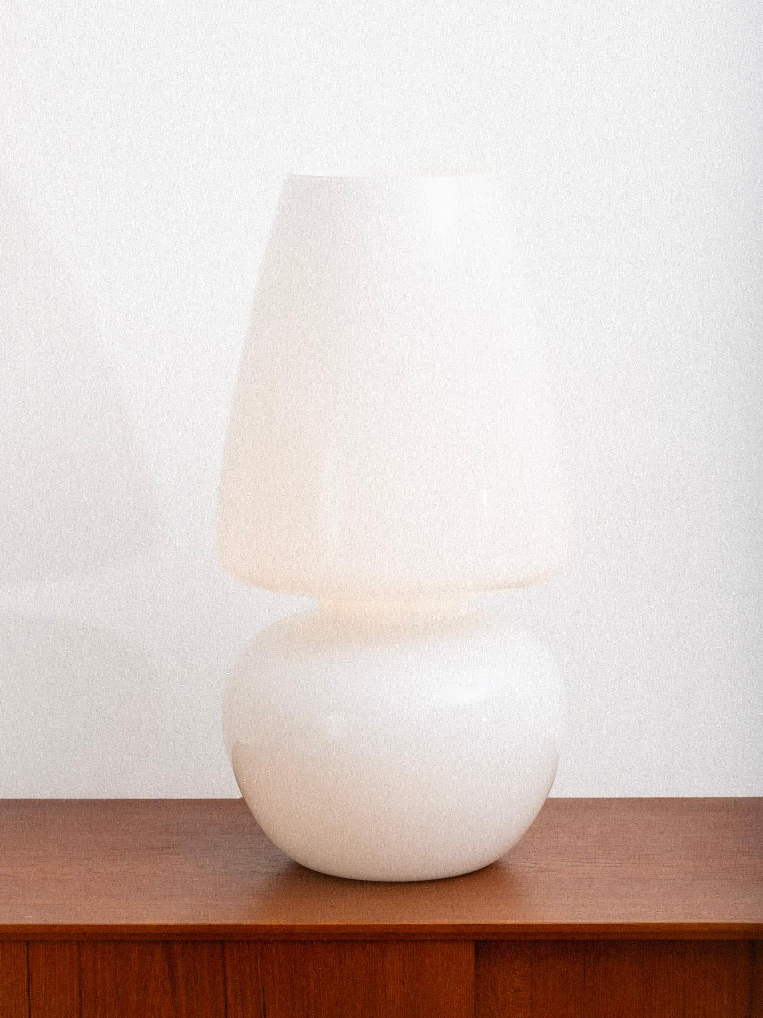 Large scale glass table lamp by VeArt, Italy. The lamp features a single-piece construction with a rounded base and flared shade form in glossy opaque glass. When illuminated, the glass produces a warm, even glow. Designed with clean, sculptural