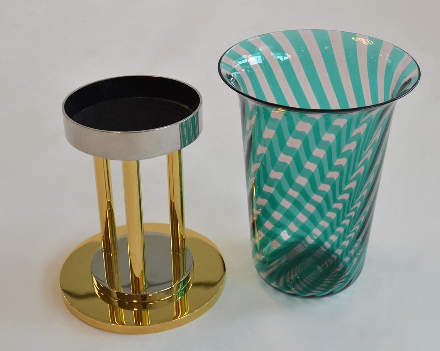 Large Italian Glass Vase or Votive in Gold and Stainless Pedestal by VeArt
Large Italian glass vase gold and stainless pedestal by VeArt. Large green / blue pattern Murano glass vase, sits on a substantial solid brass and polished steel pedestal