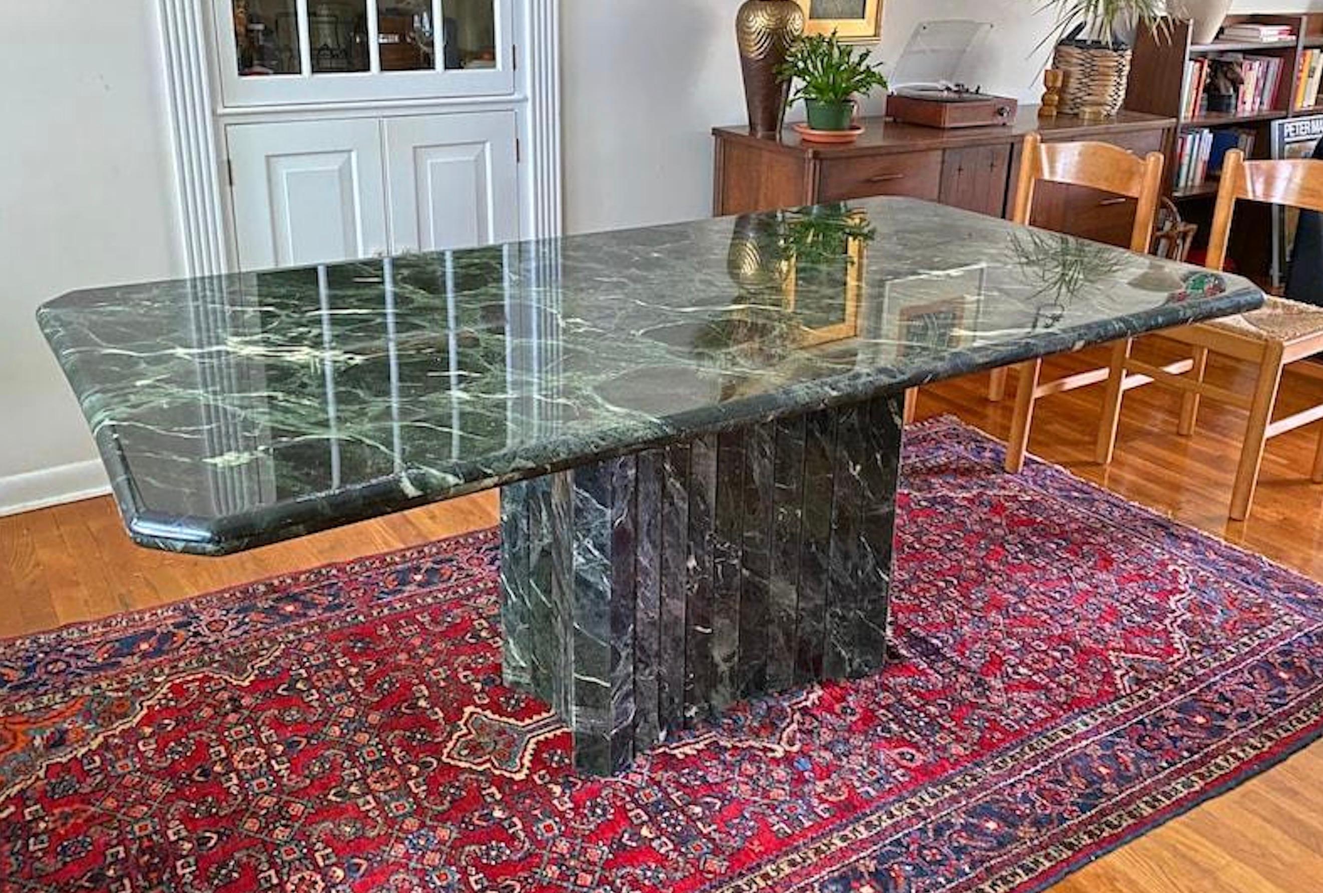 This Large 1970s Italian Green Verde Marble Stone Rectangular Pedestal Dining Table is a statement of timeless elegance. Crafted with meticulous attention to detail, the table boasts a stunning marble stone top. Designed to be versatile, this