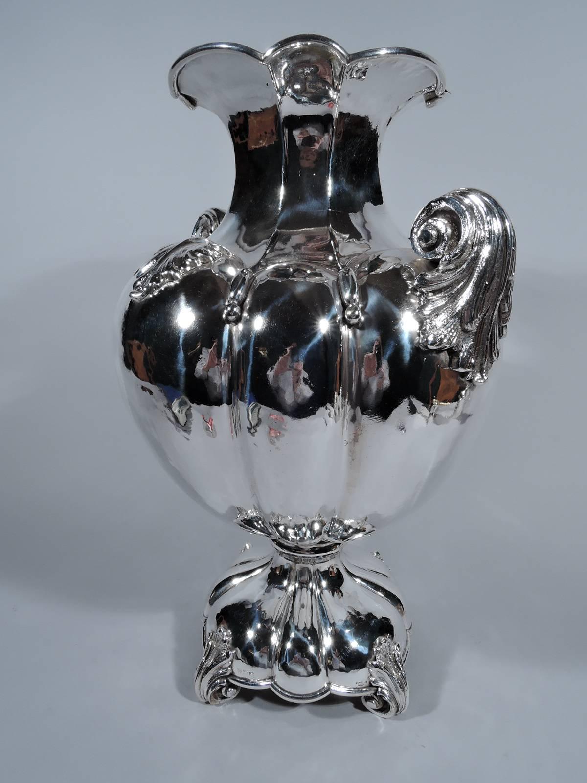 Large hand-hammered silver amphora vase. Made by Corradini in Bologna. Traditional form with alternating wide and narrow lobes on body and foot. Faceted neck with scalloped rim. Leaf-mounted volute scroll side handles and corner supports. Bold