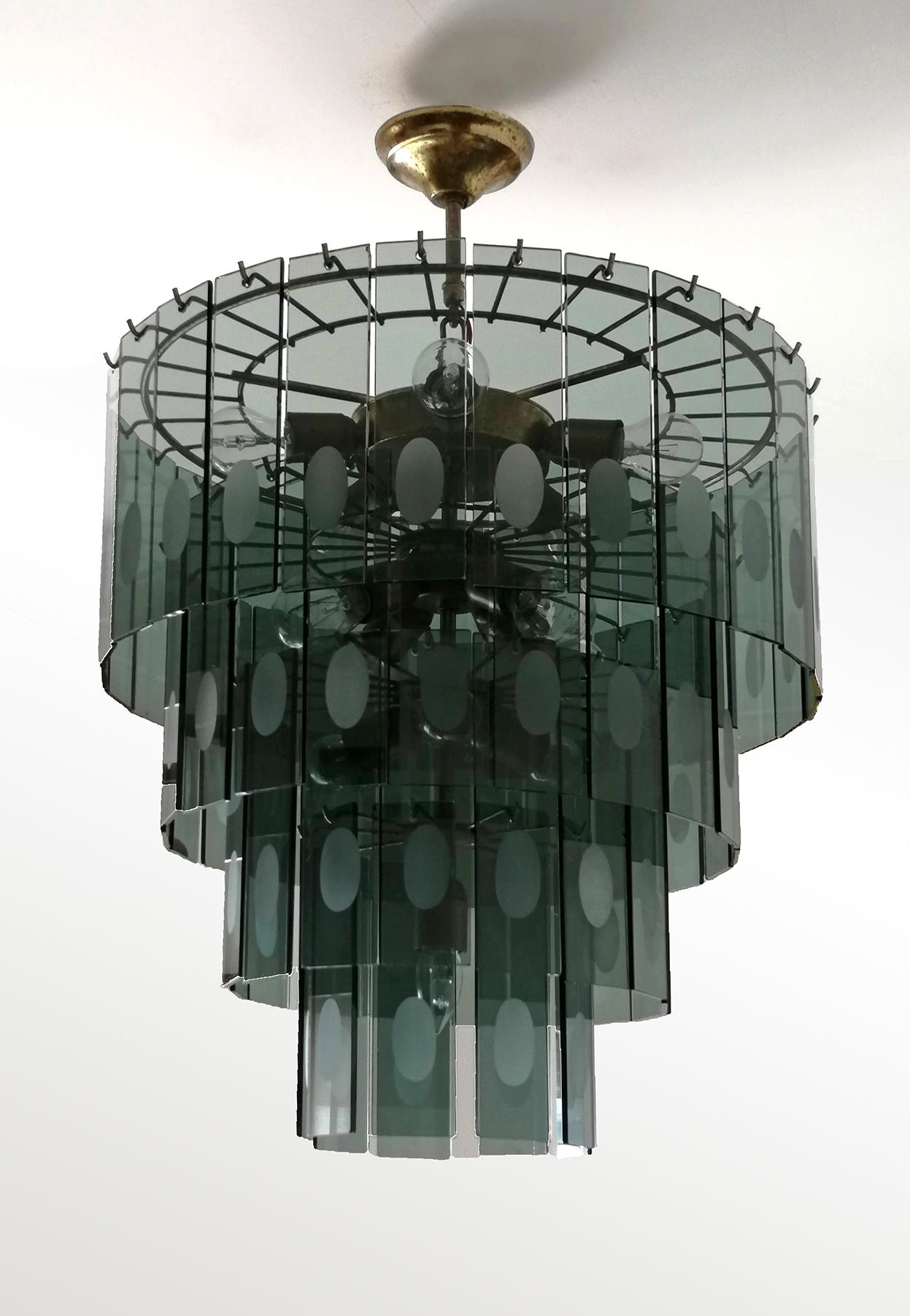 This fabulous Mid-Century Modern chandelier from the 1970s is attributed to Fontana Arte. It holds 13 candelabra sockets.
Vintage condition, some patina to the brass and a few flea bites on glass consistent with age and use.

Measures:
Diameter