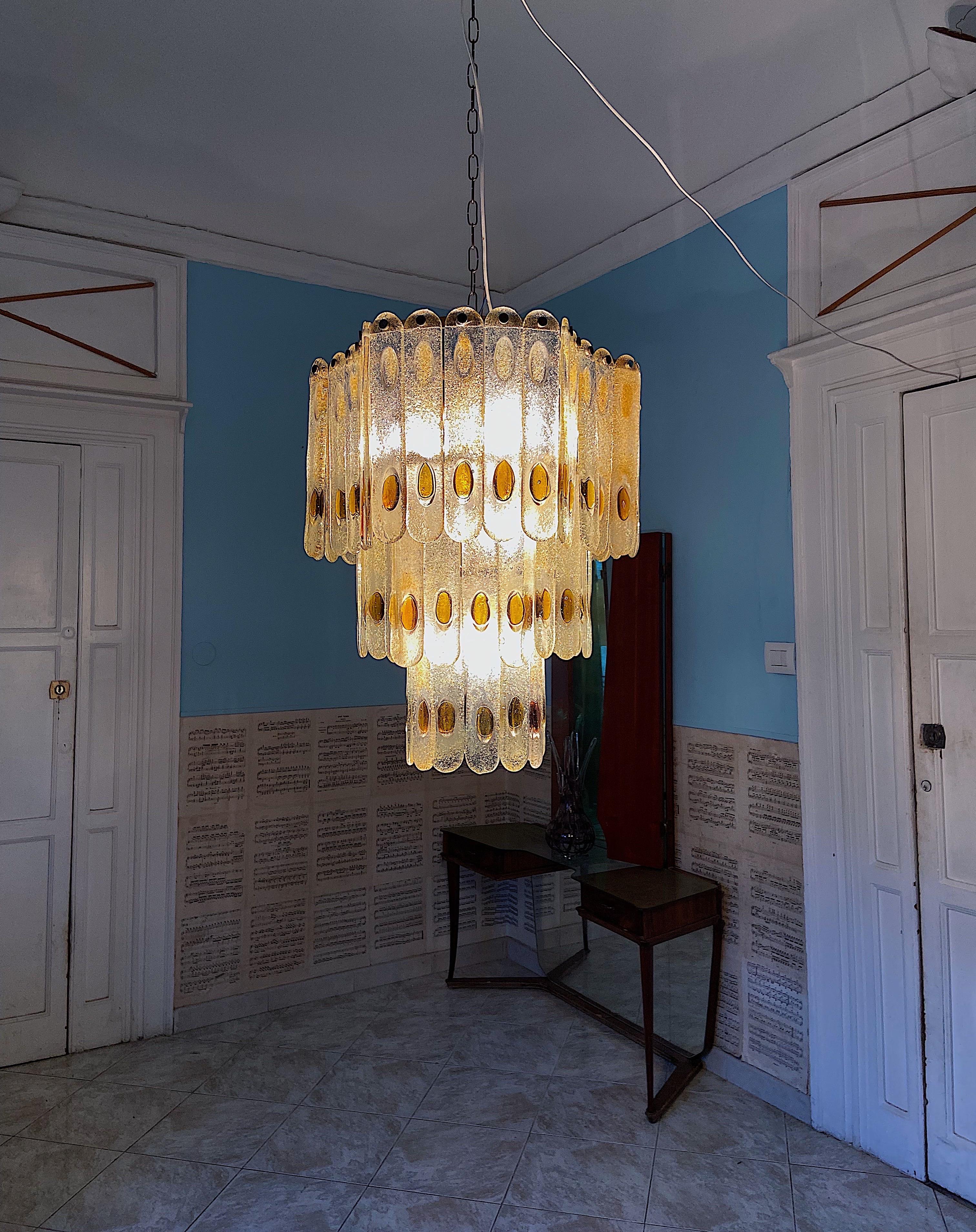 Mid-Century modern chandelier by Mazzega, Murano. 61Murano glasses set on a metal base consisting of 3 tiers.
The light has 7 bulbs.

Details
Creator: Mazzega, Murano
Dimensions: Height without chain 63 cm Diameter: 50 cm.
Materials and