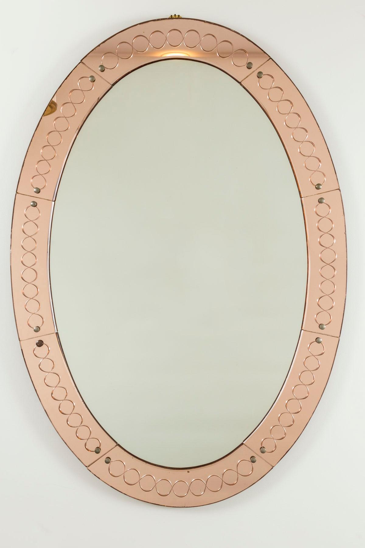A very lovely large oval shaped mirror composed of segmented salmon colored glass etched with a unique and unfussy continuous circular design
Dating: 1940-1950ca
Origin: Italy
Condition: Very Good Vintage condition with signs of time but without