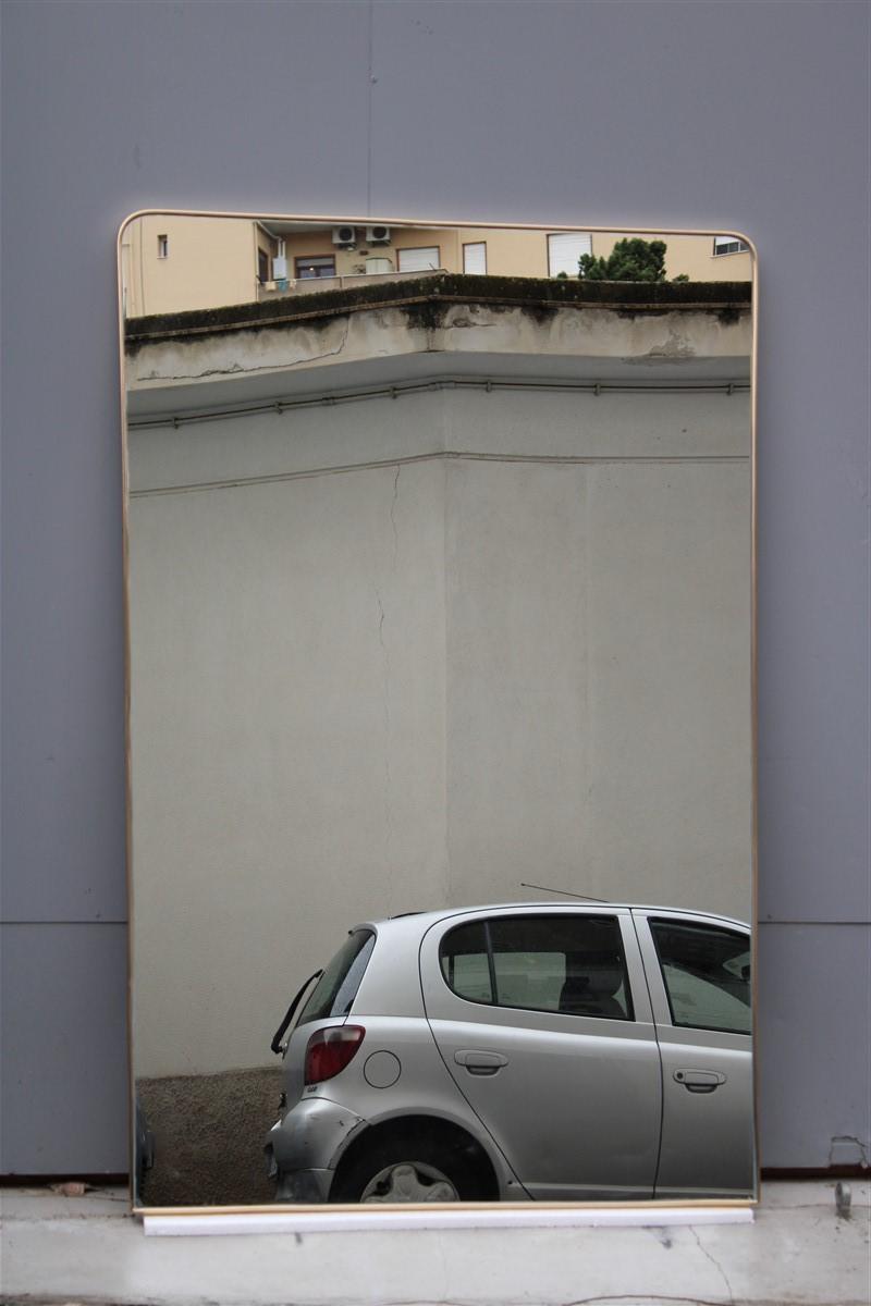 Large Italian mid-century wall mirror with rounded minimal gold brass frame

Measure: lower width 103 cm.